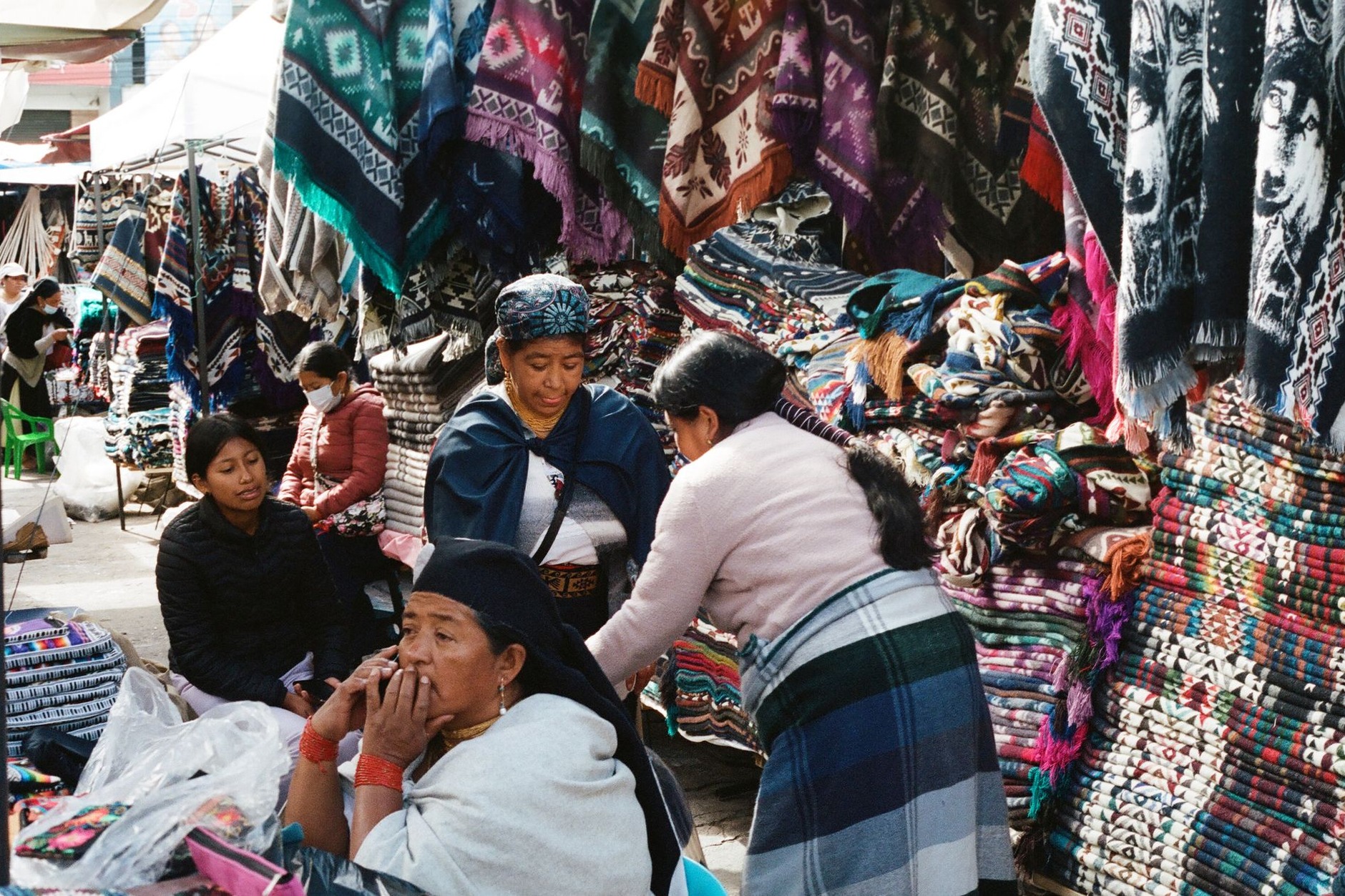 Vibrant woven woolen blankets ponchos and colorful indigenous textiles on display at Otavalo market in Ecuador