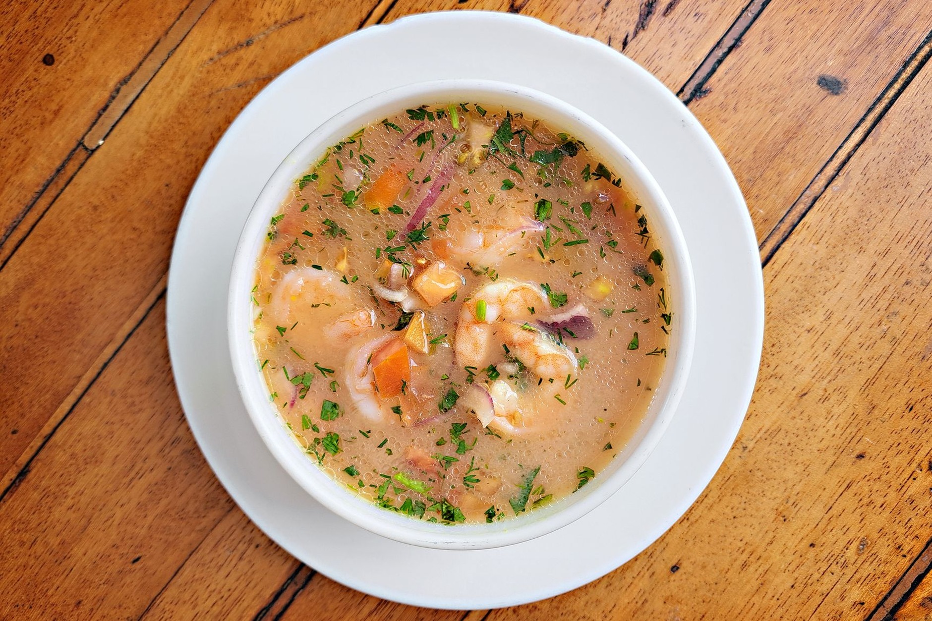 Traditional Ecuadorian Locro de Papa potato and cheese soup served with sliced fresh avocado and crumbled farmer cheese