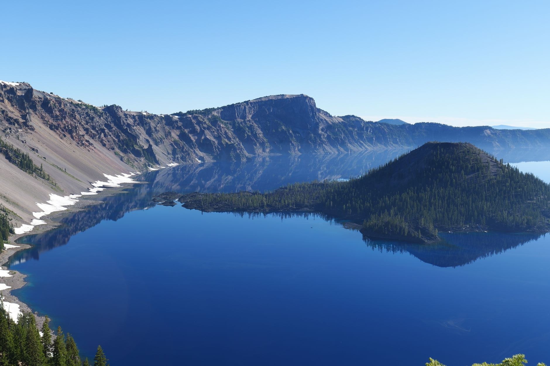 Deep sapphire blue waters of Lake Coatepeque filling a volcanic caldera surrounded by lush green hills