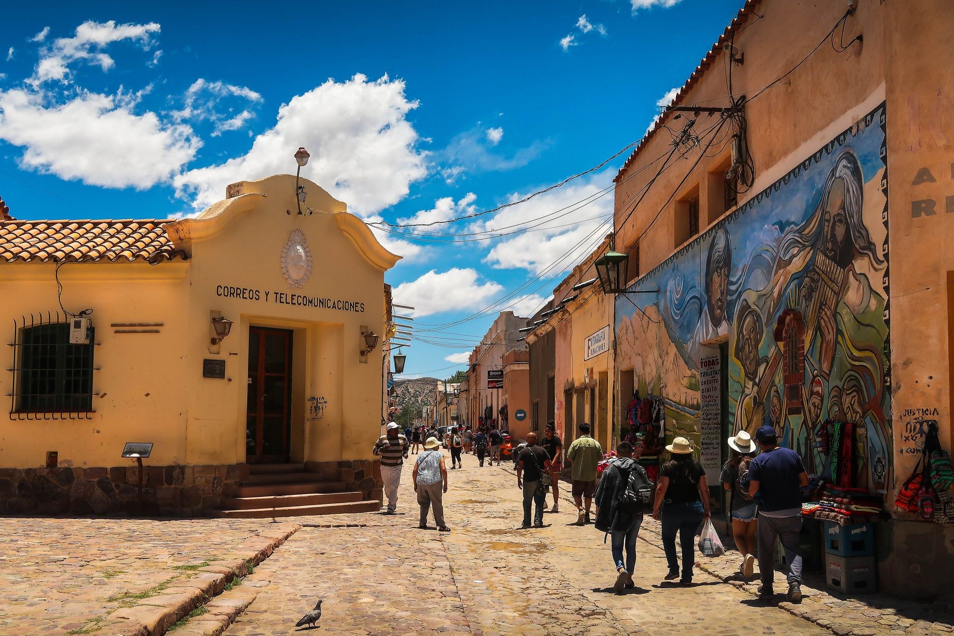 Cobblestone mountain street lined with colorful houses adorned with painted folklore murals in Ataco