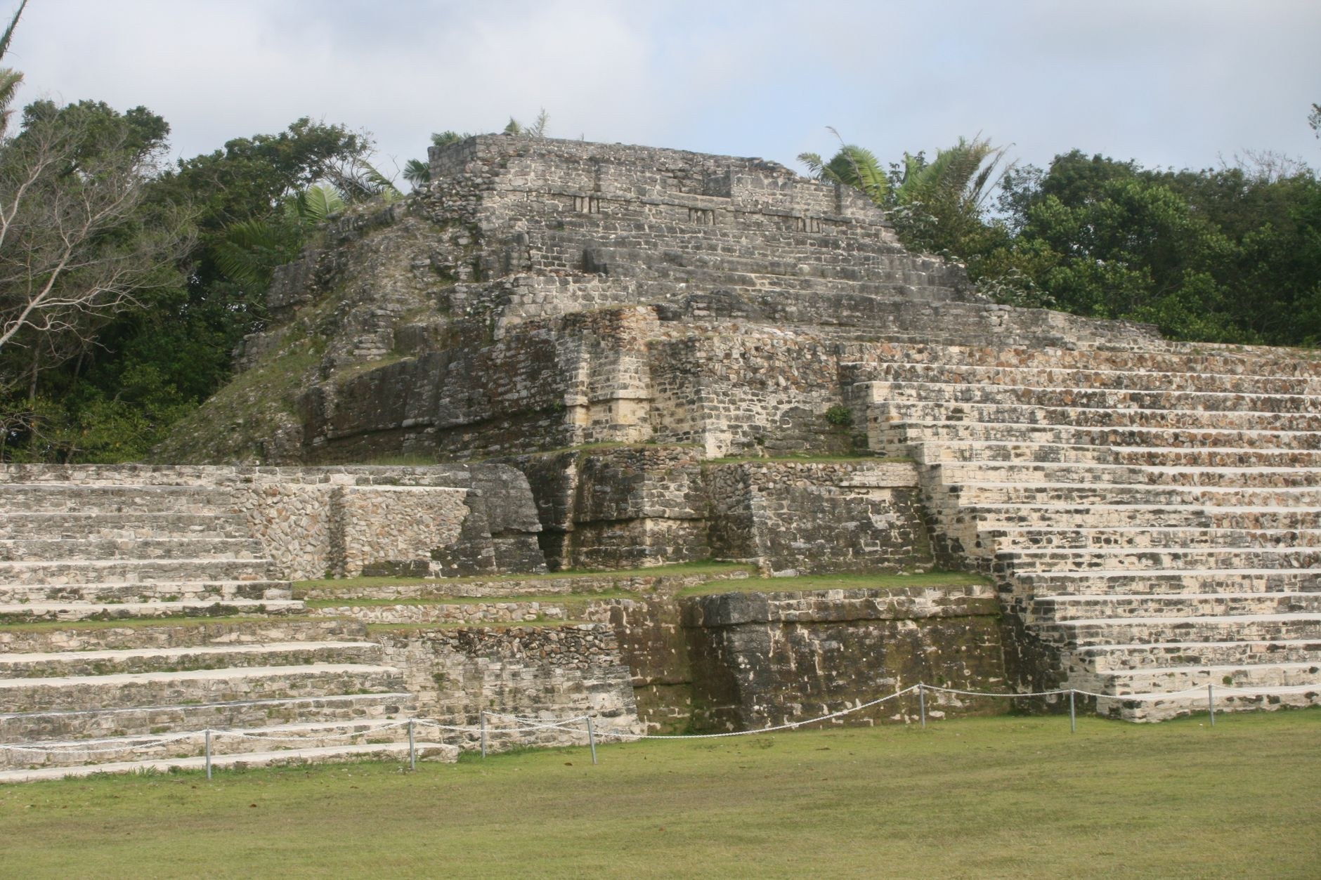 An ancient stepped stone Maya pyramid complex rising beneath tropical trees at Tazumal