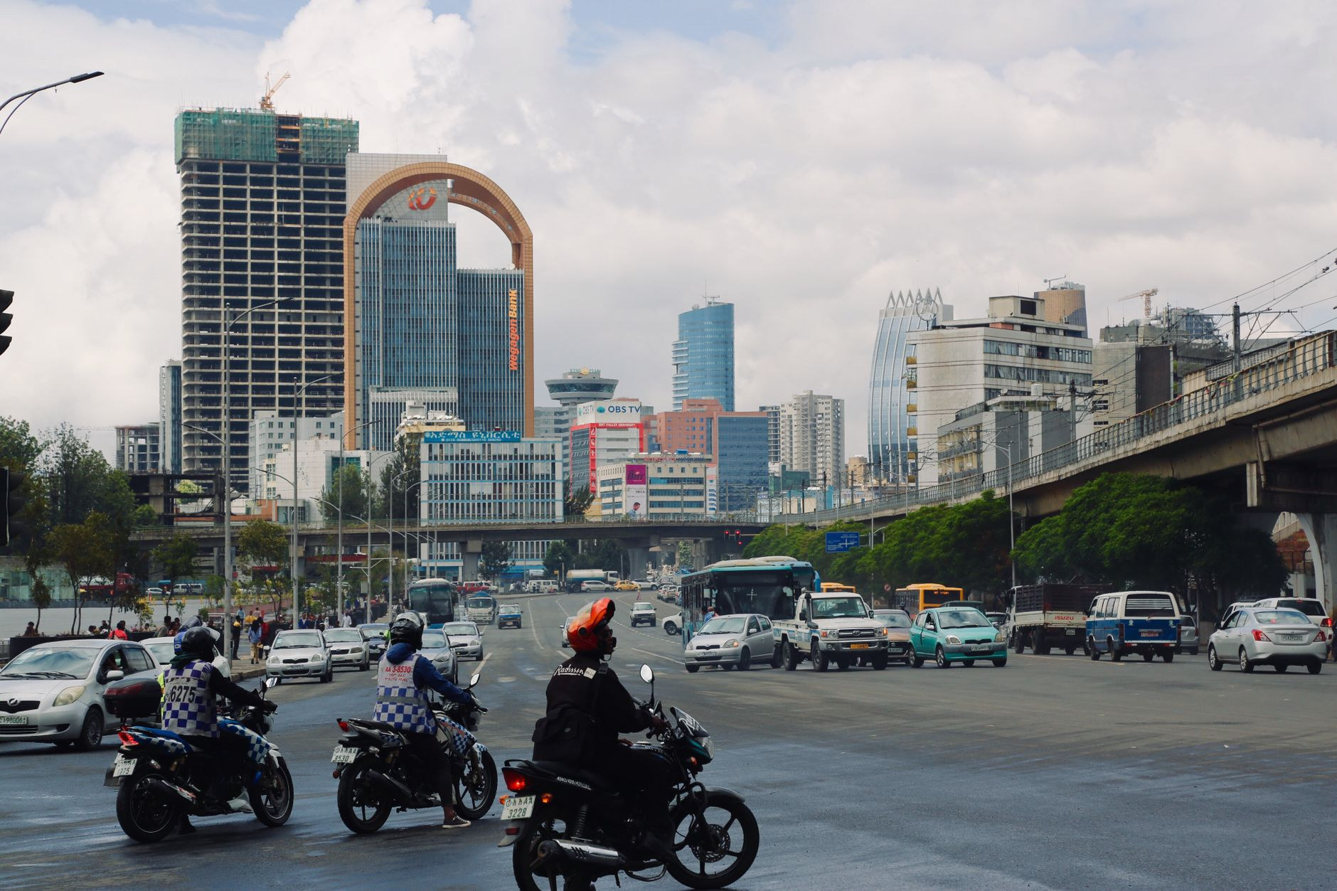 Urban street scene in central Addis Ababa showing vehicular traffic, city buses, and commercial buildings under highland daylight