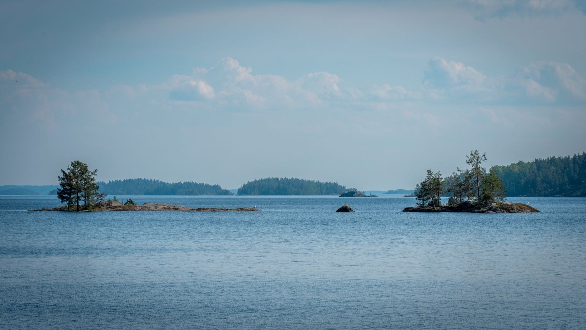 Aerial vista of thousands of forested pine islands and glassy freshwater channels across Lake Saimaa in summer
