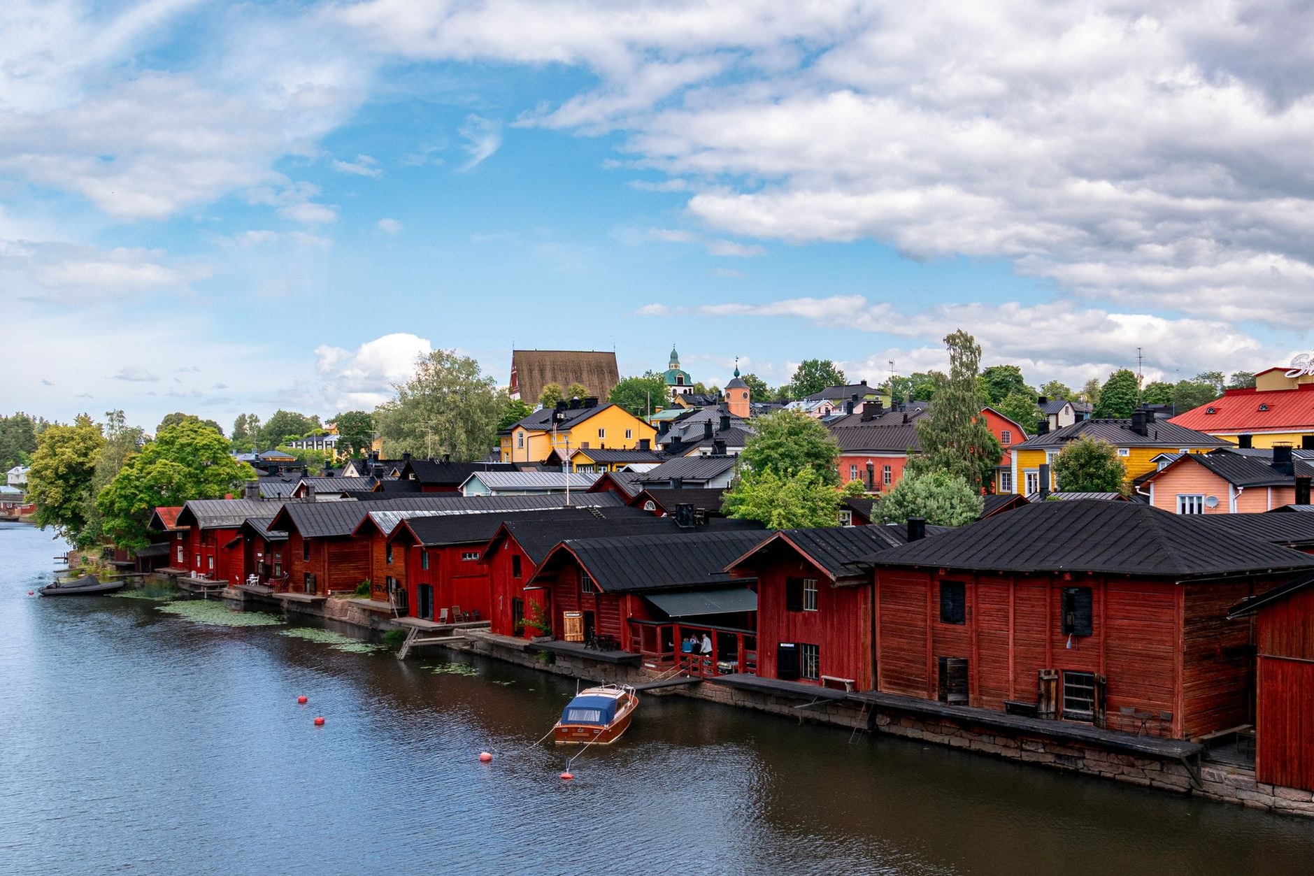 Red-ochre painted riverside timber storehouses and cobbled lanes in the historic medieval center of Porvoo