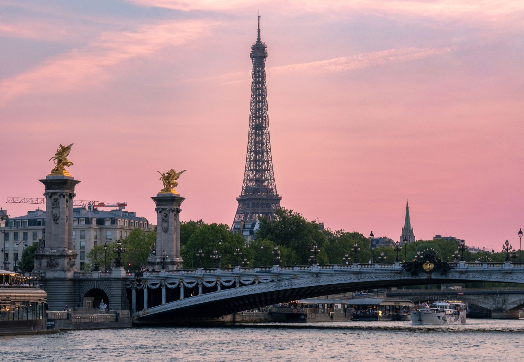 Eiffel Tower rising above the River Seine at golden hour in Paris