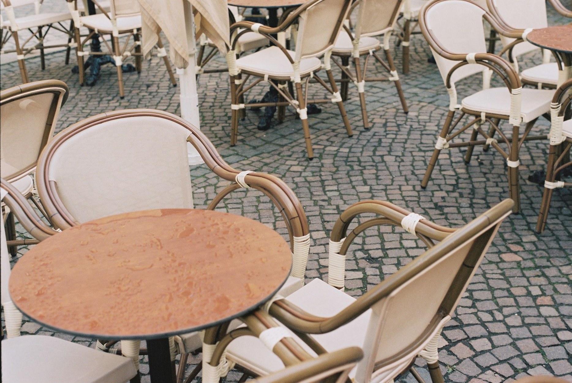 Traditional Parisian outdoor bistro terrace with wicker chairs and small round tables