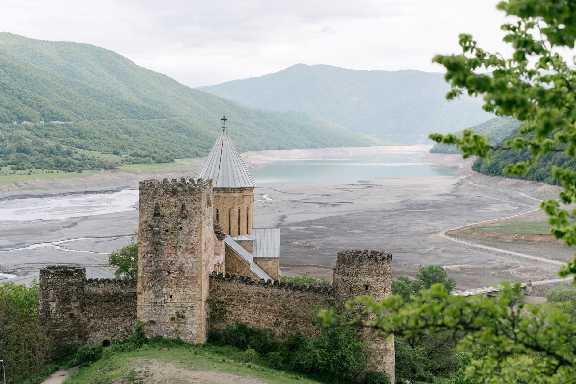 Medieval stone fortress towers of Ananuri overlooking the turquoise waters of the Zhinvali Reservoir on the Georgian Military Highway