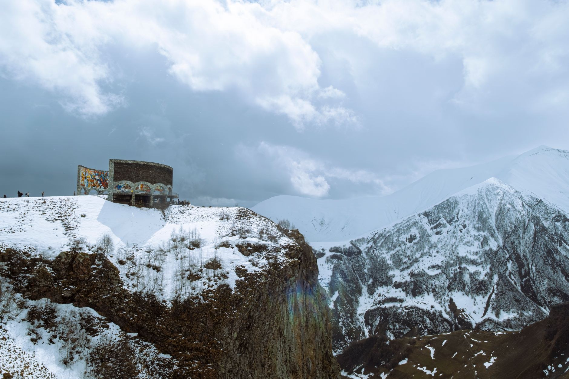 Scenic high mountain pass road winding through the snow-dusted peaks of the Greater Caucasus along the Georgian Military Highway