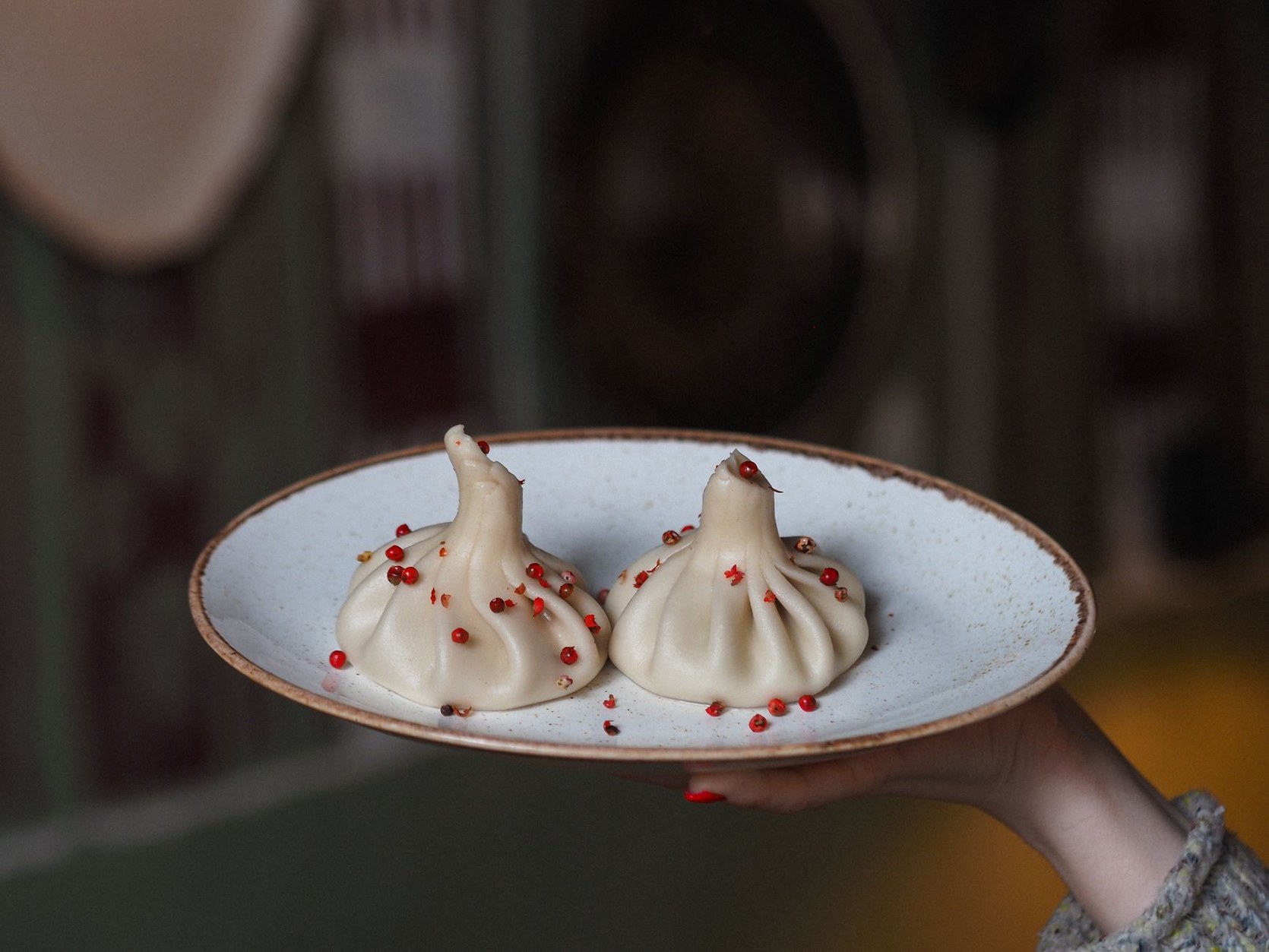 Steaming platter of traditional Georgian spiced meat khinkali dumplings with black pepper