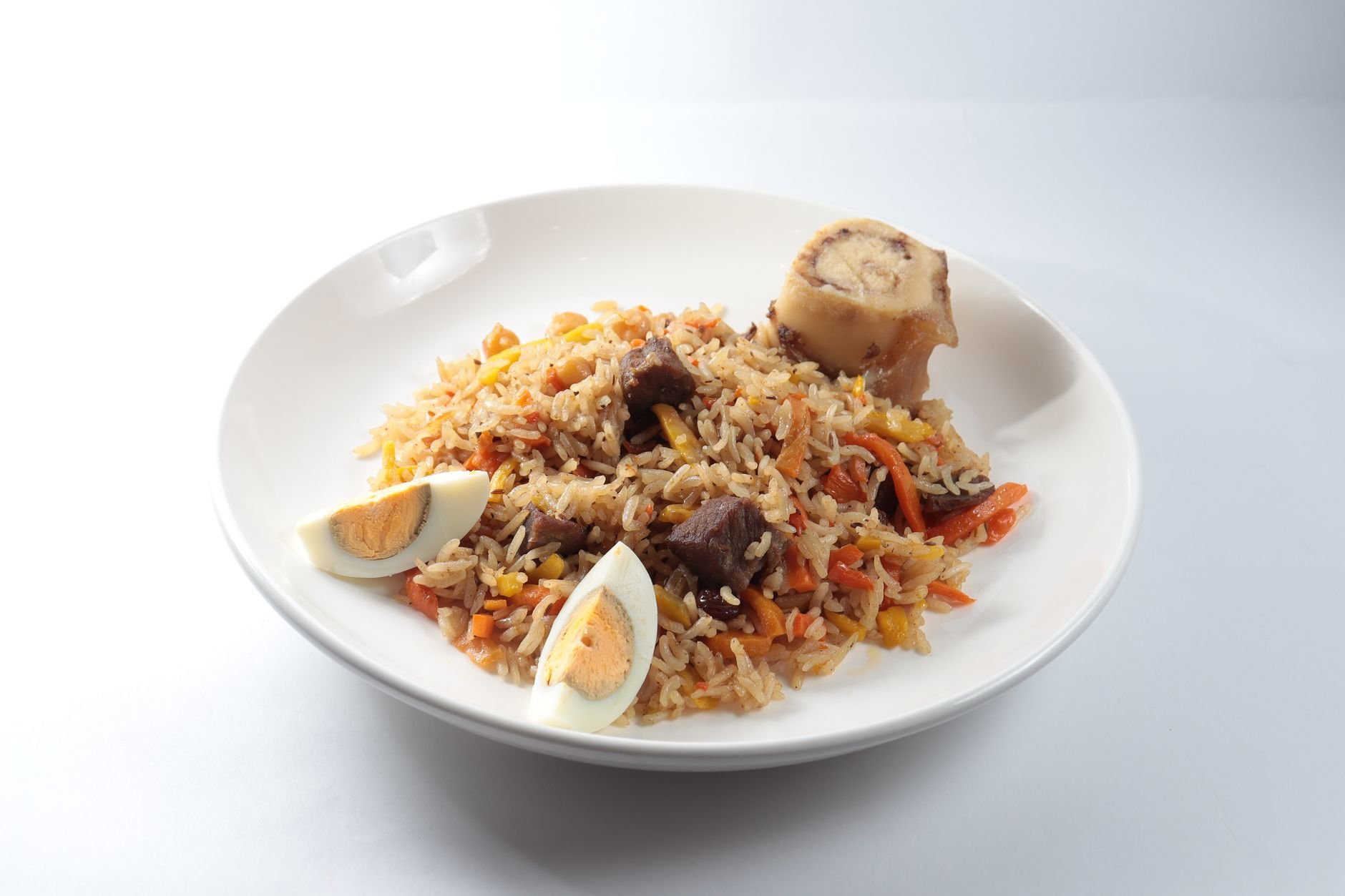 Rich orange Ghanaian jollof rice served alongside crispy fried plantains (dodo), roasted chicken, and spicy shito pepper sauce