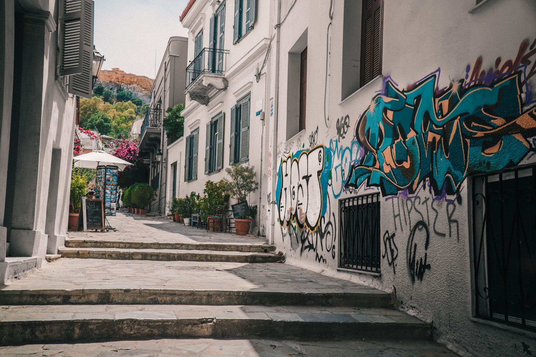 Narrow cobblestone pedestrian street lined with outdoor tavernas in Plaka, Athens