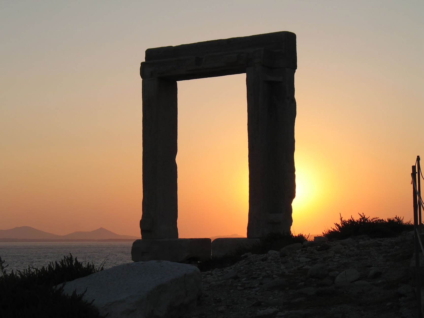 Colossal ancient marble doorway of the Portara framed against an Aegean sunset in Naxos