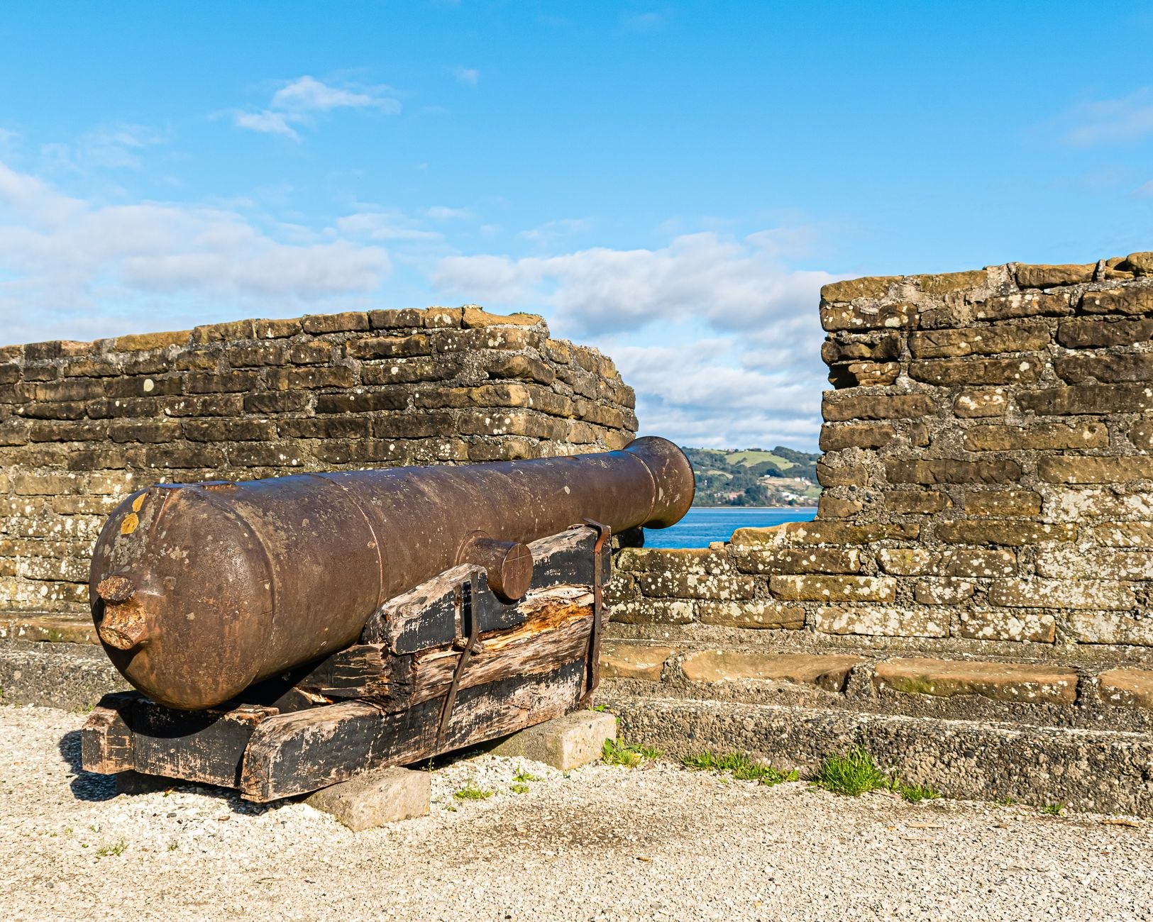Historic 18th-century stone battlements and cannons overlooking a panoramic vista of the Caribbean coastline
