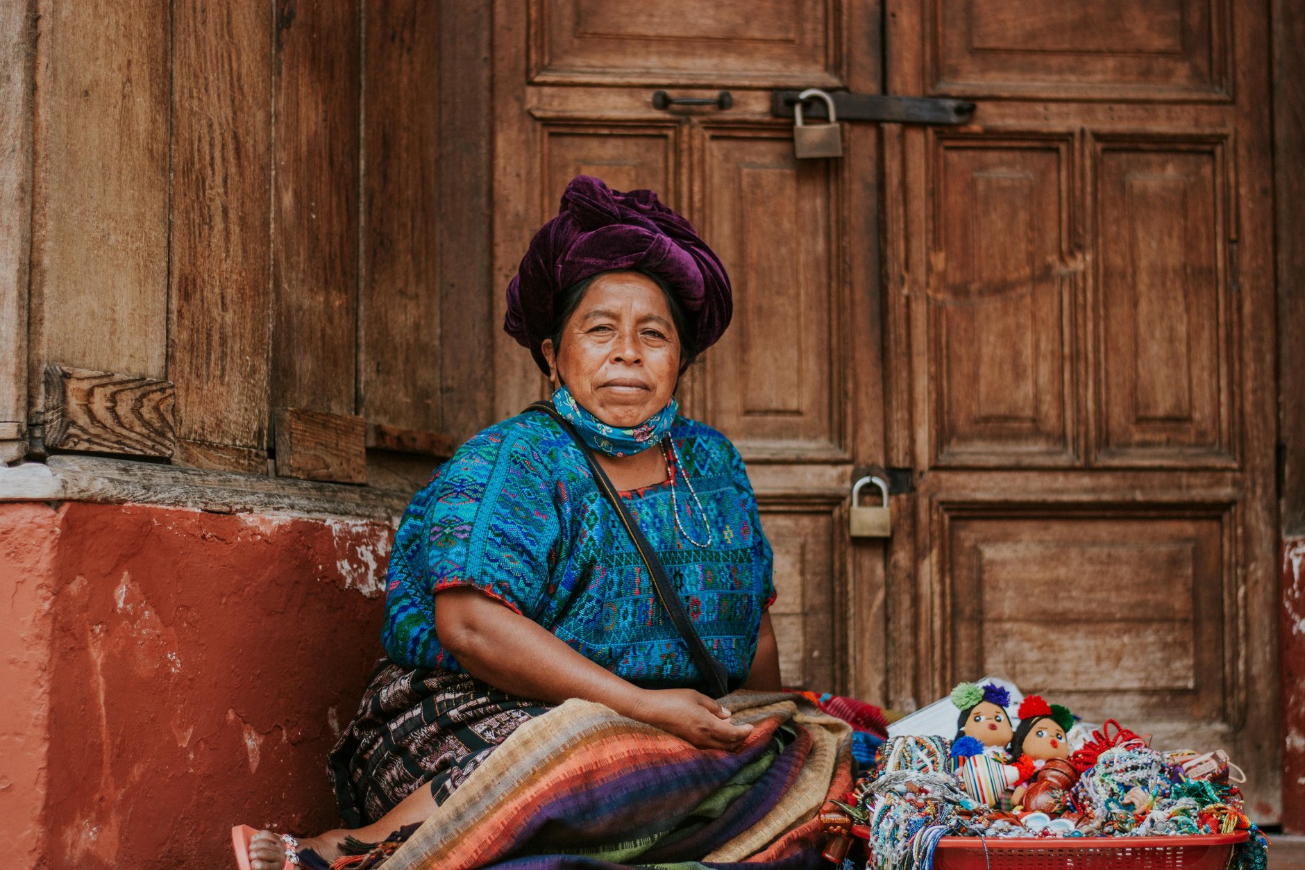Indigenous Mayan woman demonstrating traditional backstrap loom weaving using naturally dyed colorful cotton threads