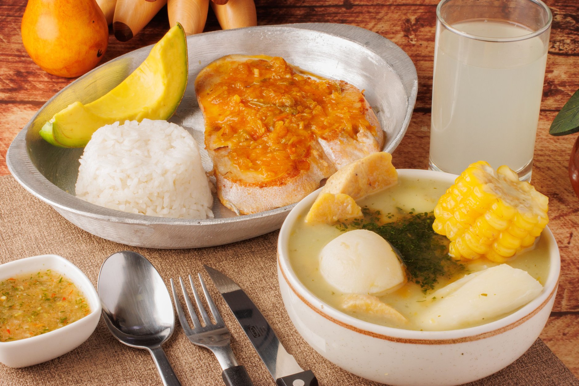 A rich bowl of traditional Guatemalan pepian stew with roasted pumpkin seed sauce, chicken, and fresh corn tortillas
