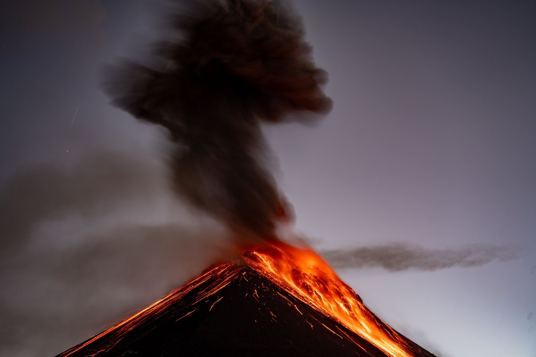 Active Volcan de Fuego erupting glowing lava and an ash plume viewed from the high-altitude camping ridge of Acatenango