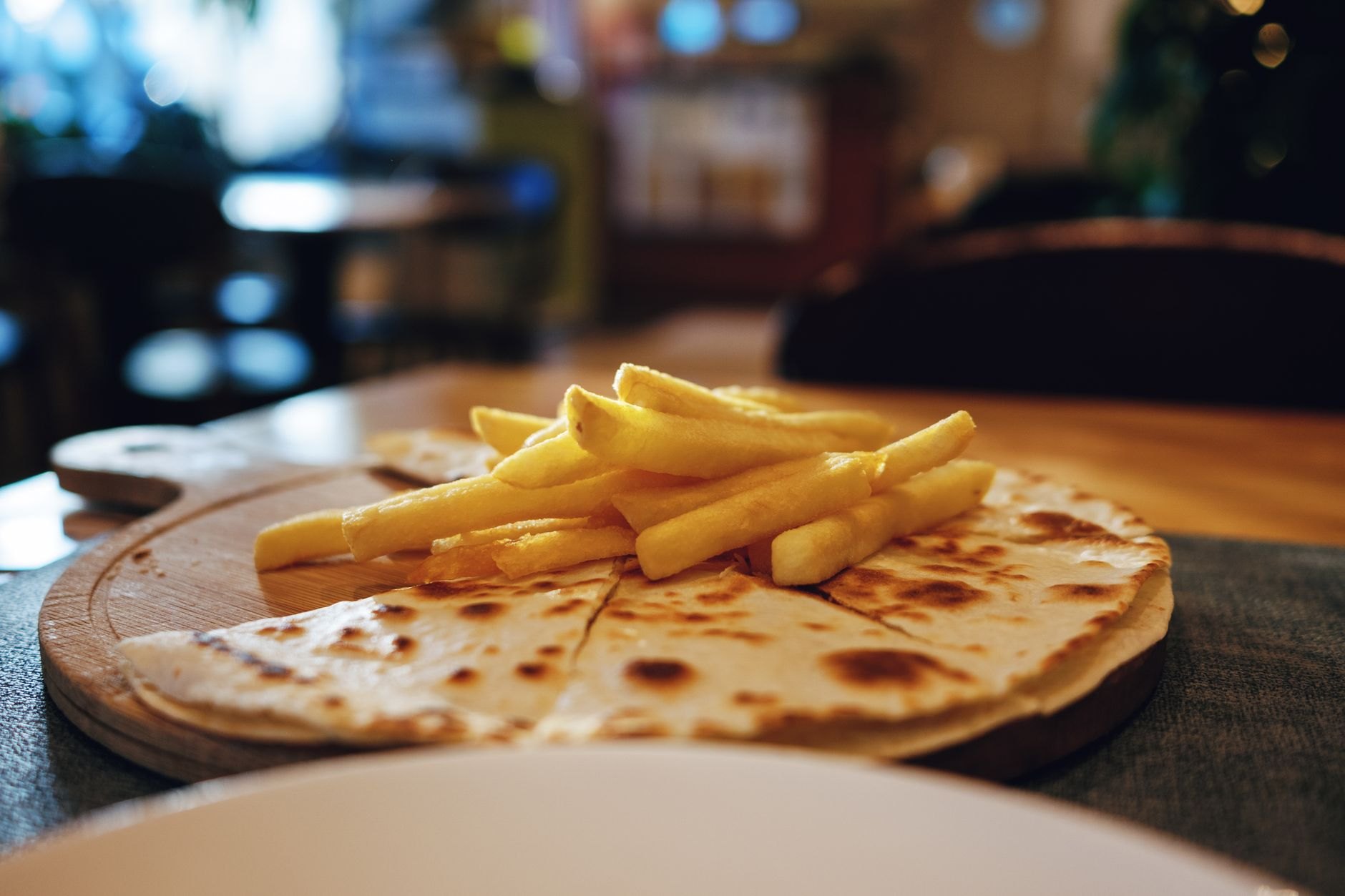 Large folded handmade flour tortilla filled with savory refried beans, Honduran mantequilla cream, avocado, and cheese