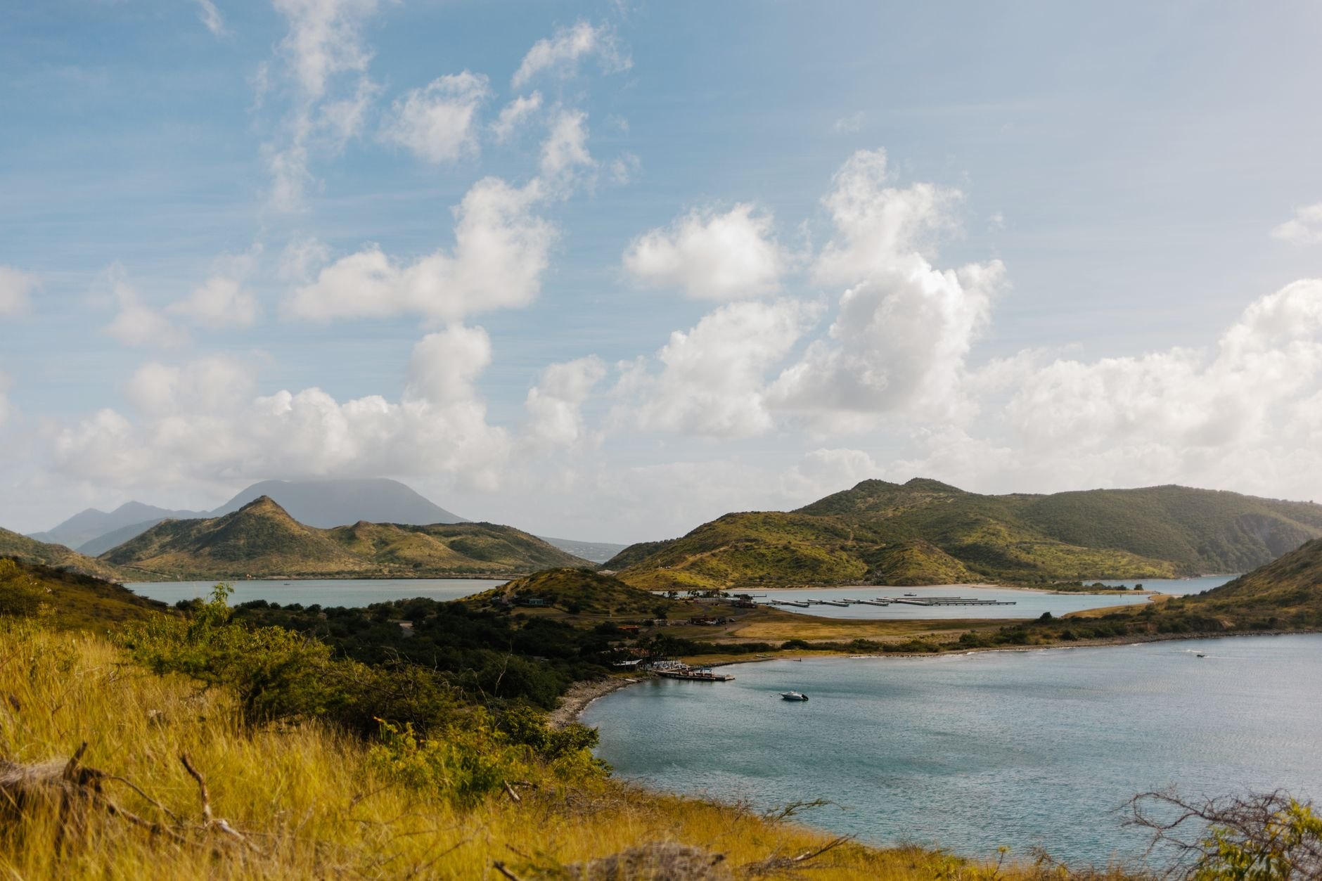 Panoramic view across the placid blue waters of Lake Yojoa bordered by emerald forested mountains