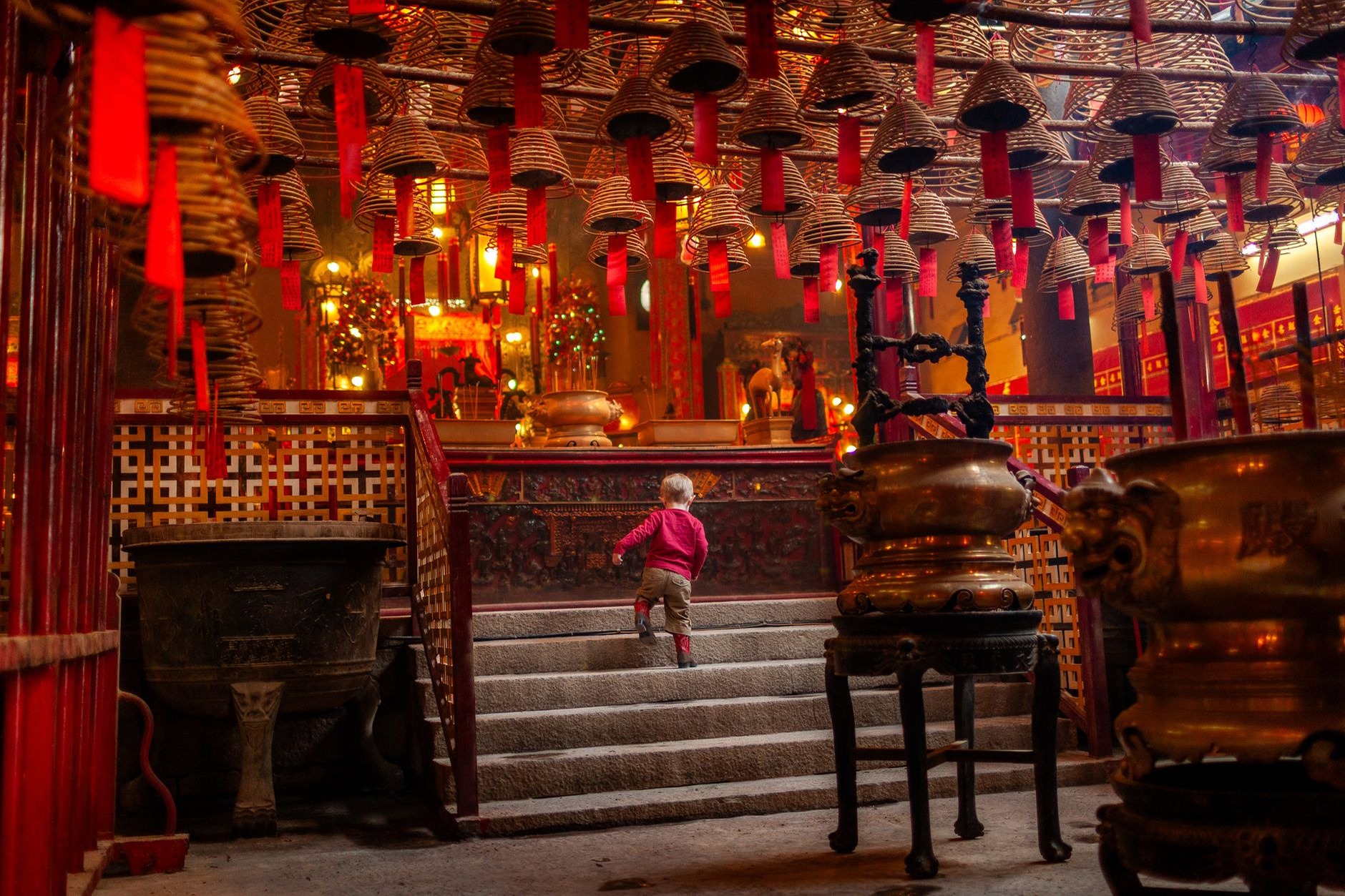 Atmospheric smoke rising from giant hanging spiral incense coils inside historic Man Mo Temple on Hollywood Road