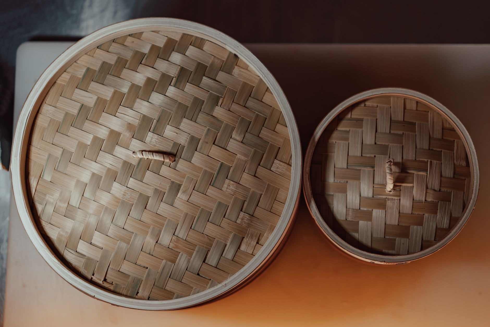 Steaming bamboo baskets filled with freshly pleated har gow shrimp dumplings and siu mai at a traditional Cantonese teahouse