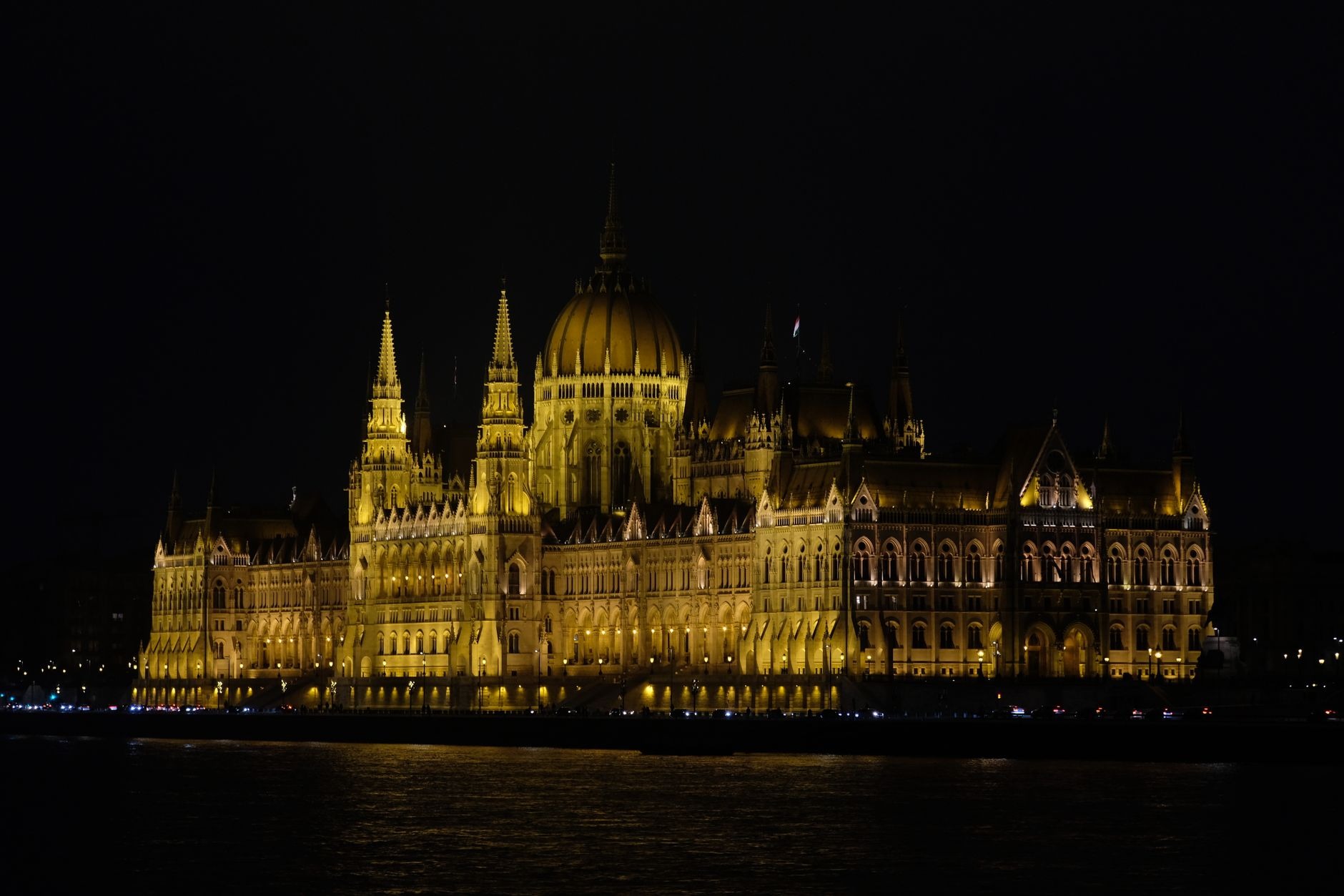 Golden evening illumination of the Hungarian Parliament Building reflected in the deep waters of the Danube River