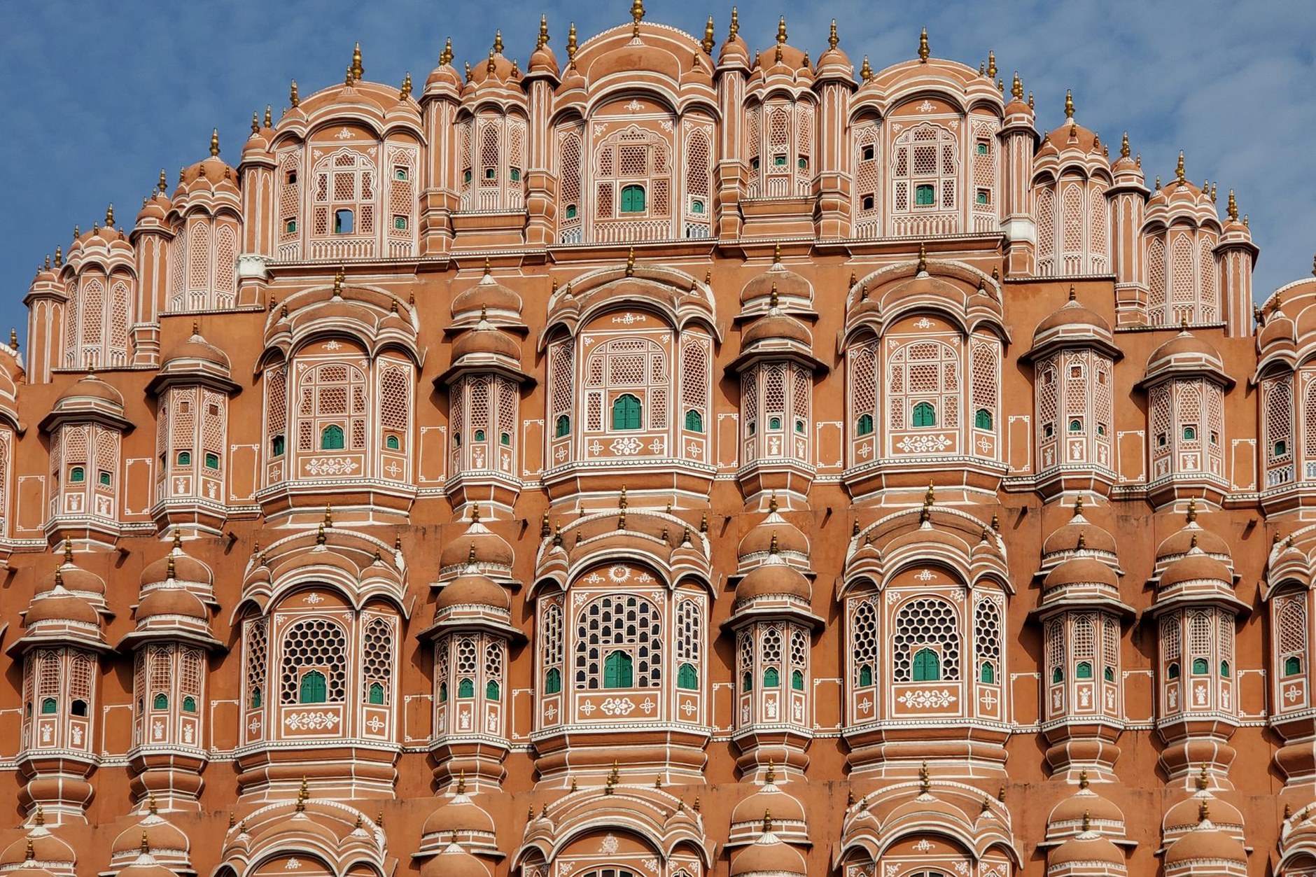 The intricately latticed pink sandstone facade of the Hawa Mahal Palace of Winds in Jaipur
