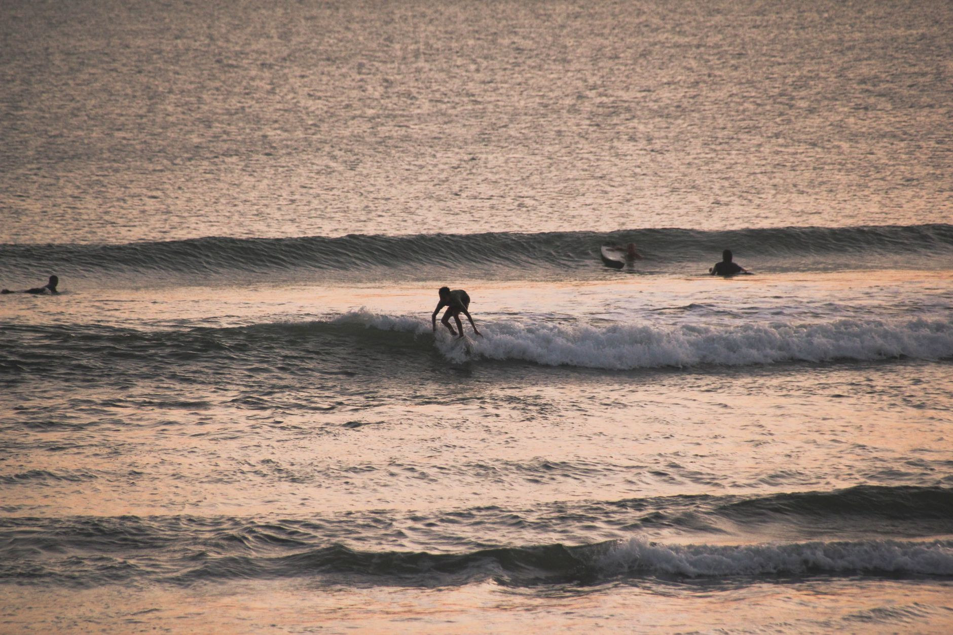 Golden hour sunset over rolling surf along a Balinese beach