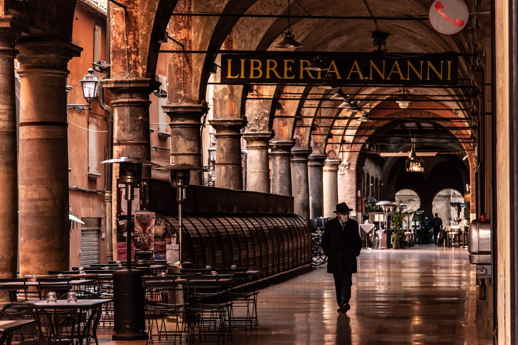 A pedestrian beneath the Portico della Morte in Bologna