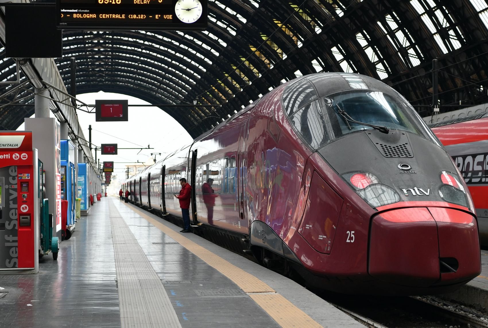 A red high-speed train at Milano Centrale station
