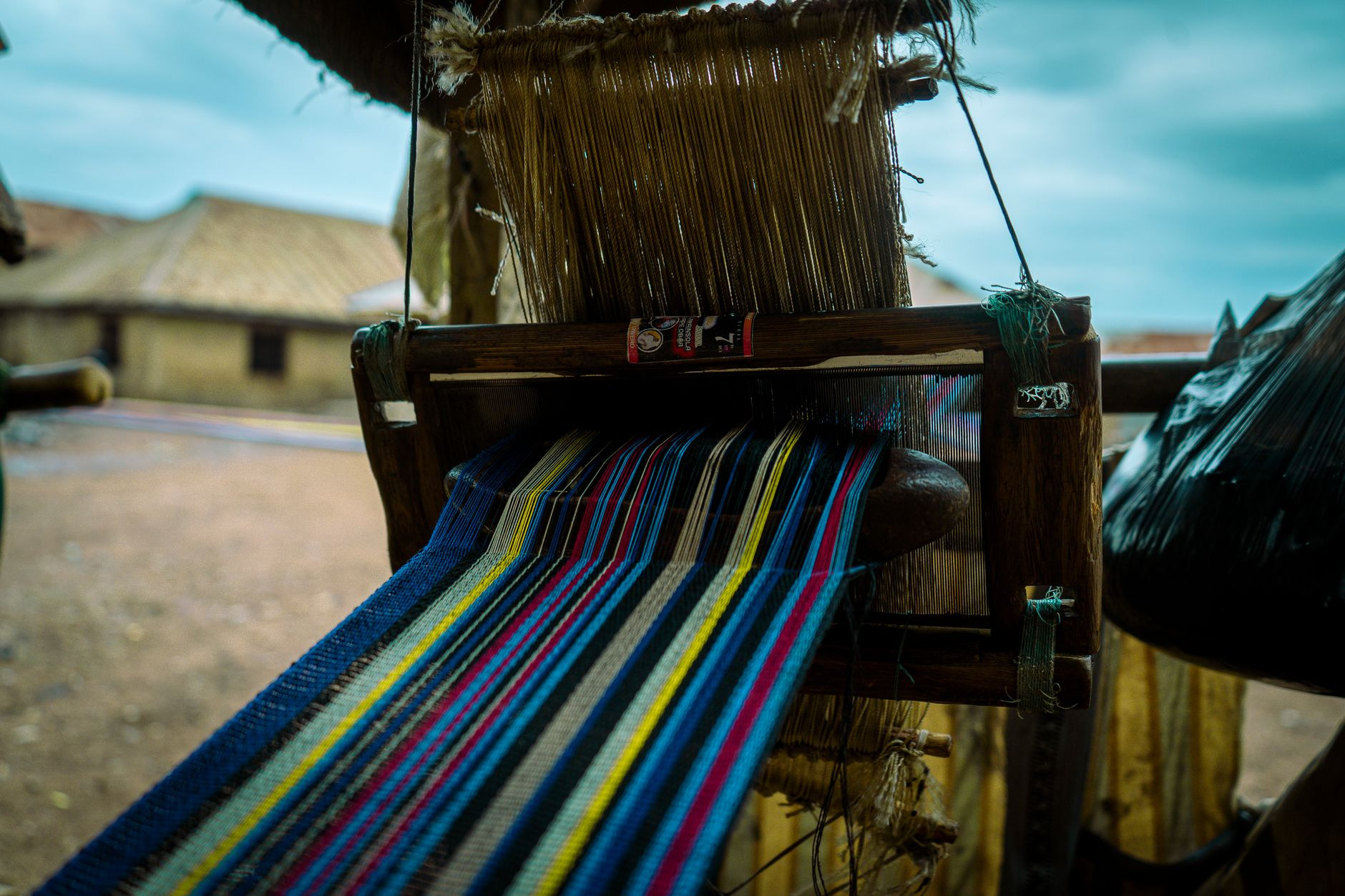 Traditional wooden handloom weaving intricate geometric textile patterns in a village workshop