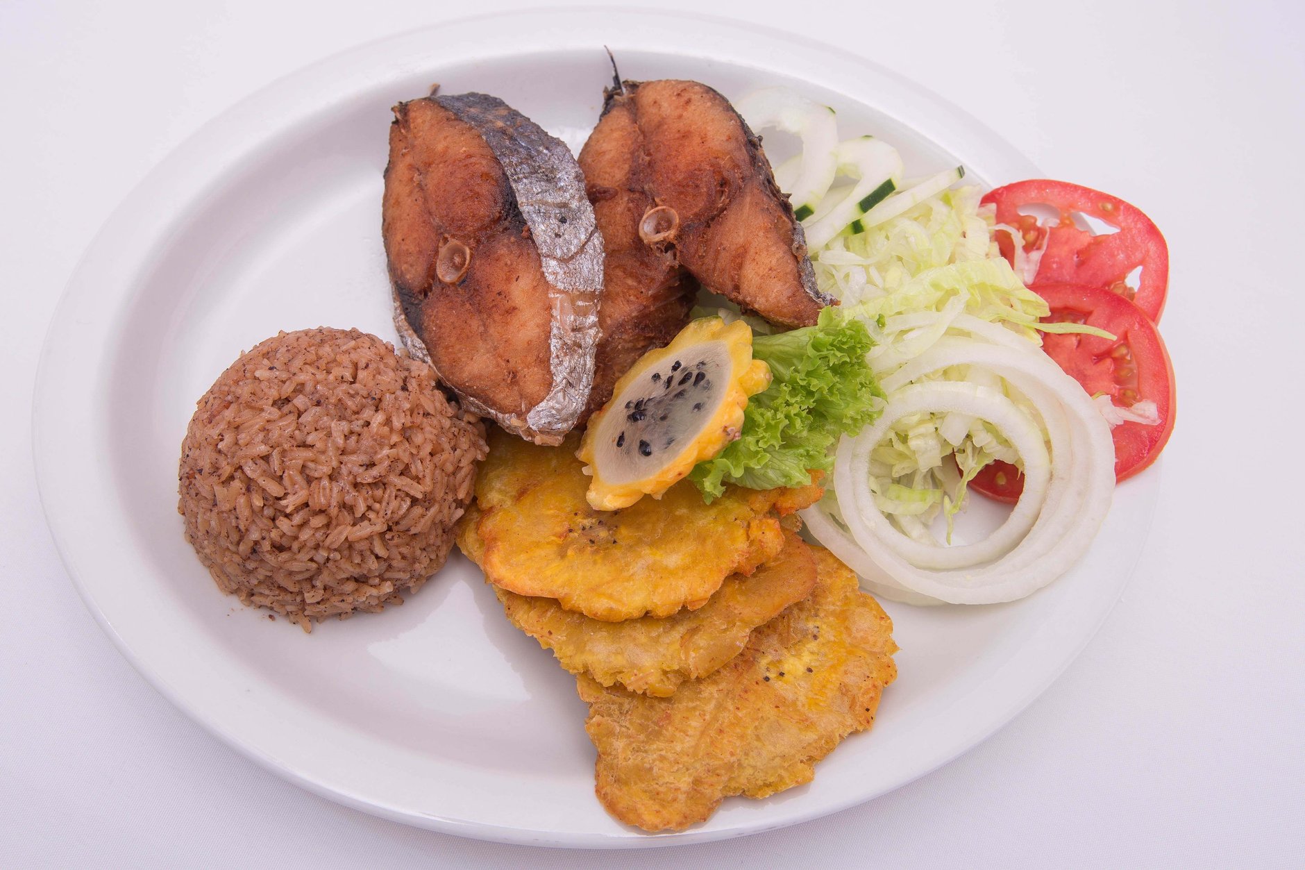 A traditional plate of ackee and saltfish sauteed with sweet peppers, onions, and scotch bonnet peppers served with fried plantains