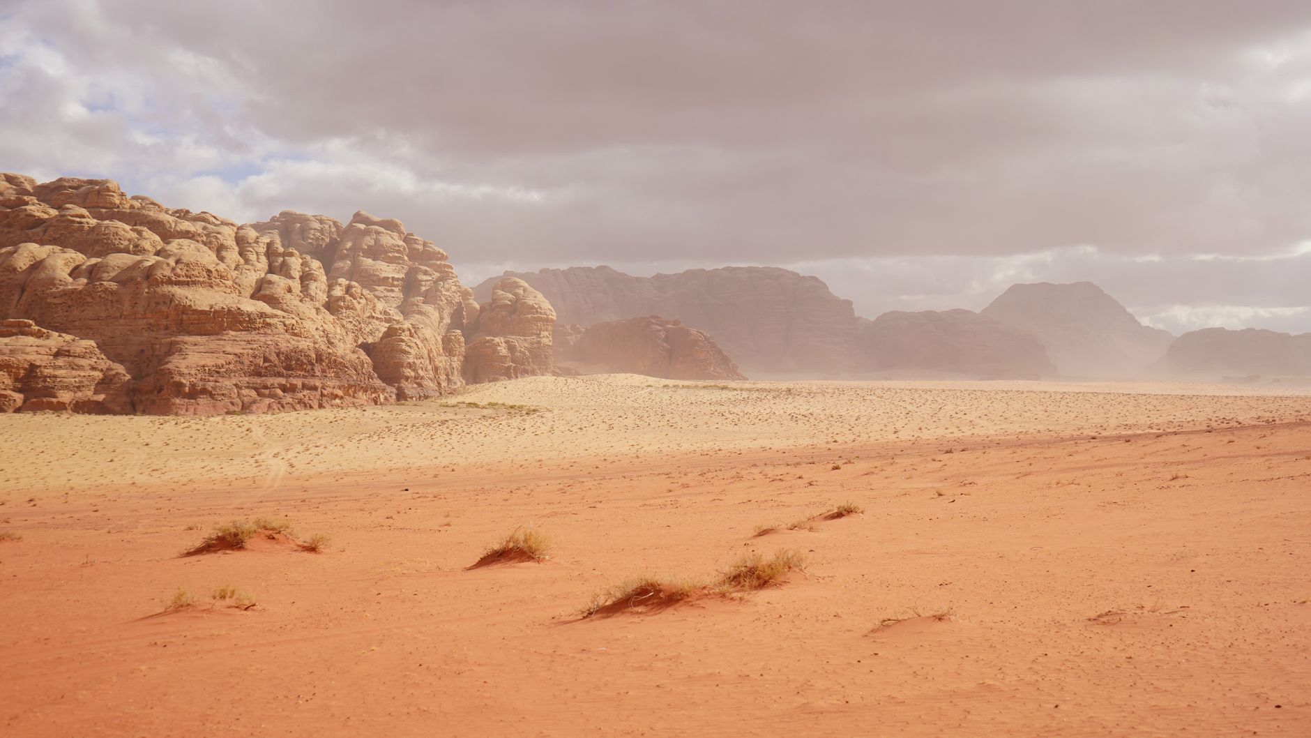 Towering red sandstone cliffs and vast desert sands of Wadi Rum