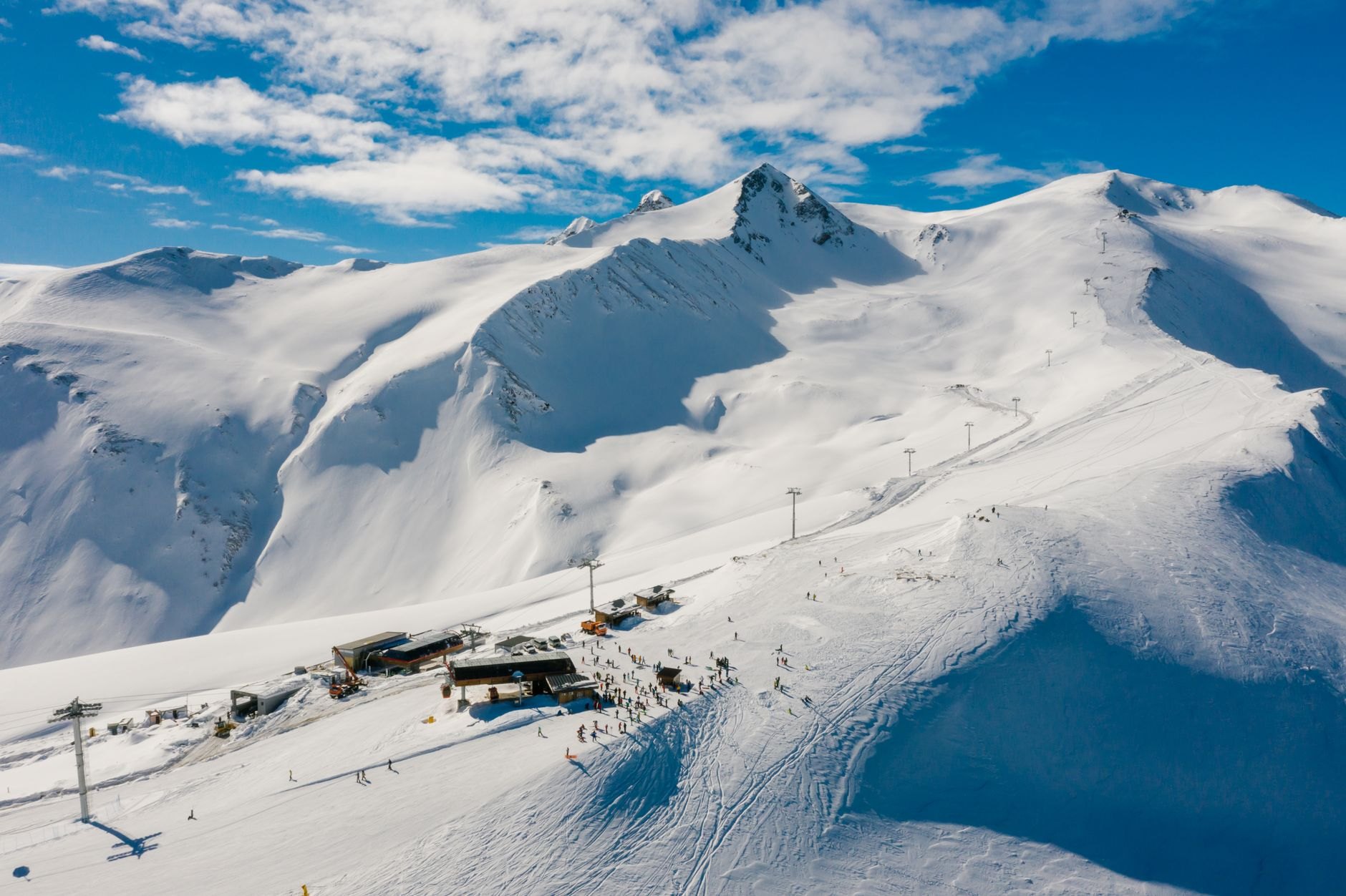 Towering snow-covered granite peaks of the Tian Shan mountains rising above the alpine meadows of Shymbulak