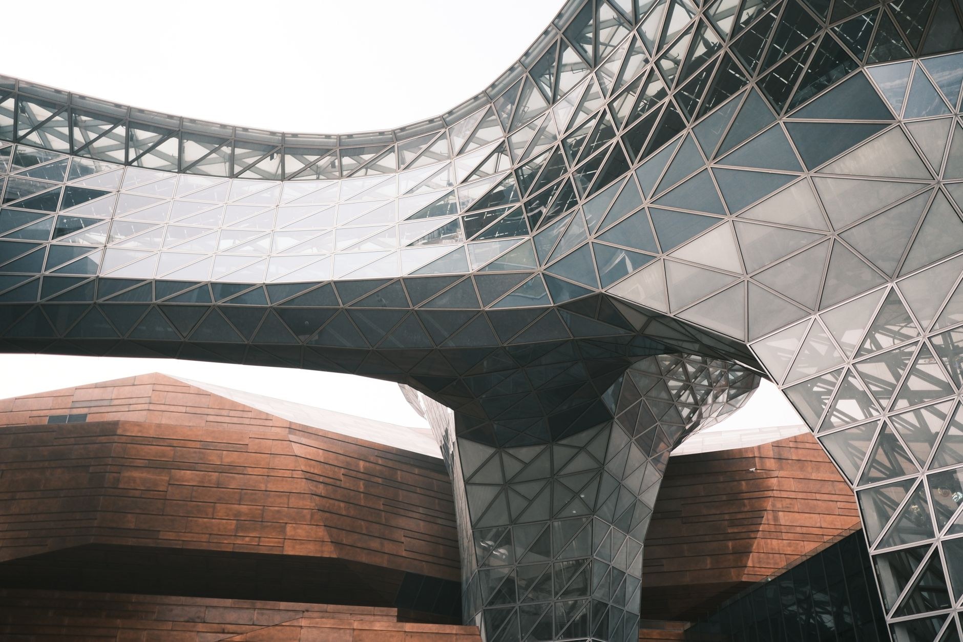 Spectacular faceted geometric glass-and-titanium pavilion buildings set against reflecting pools