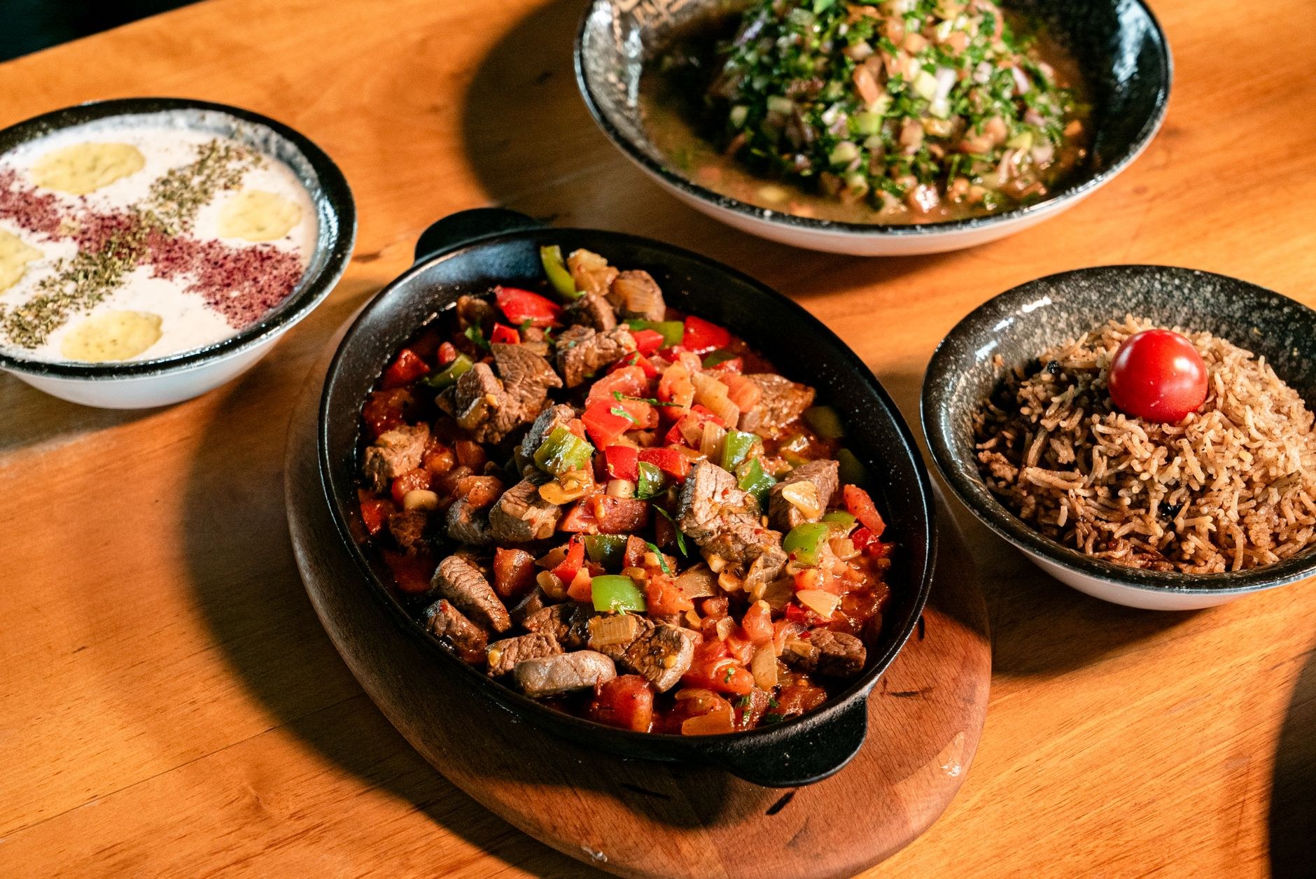 A generous platter of golden fragrant spiced basmati rice topped with tender braised lamb and roasted nuts