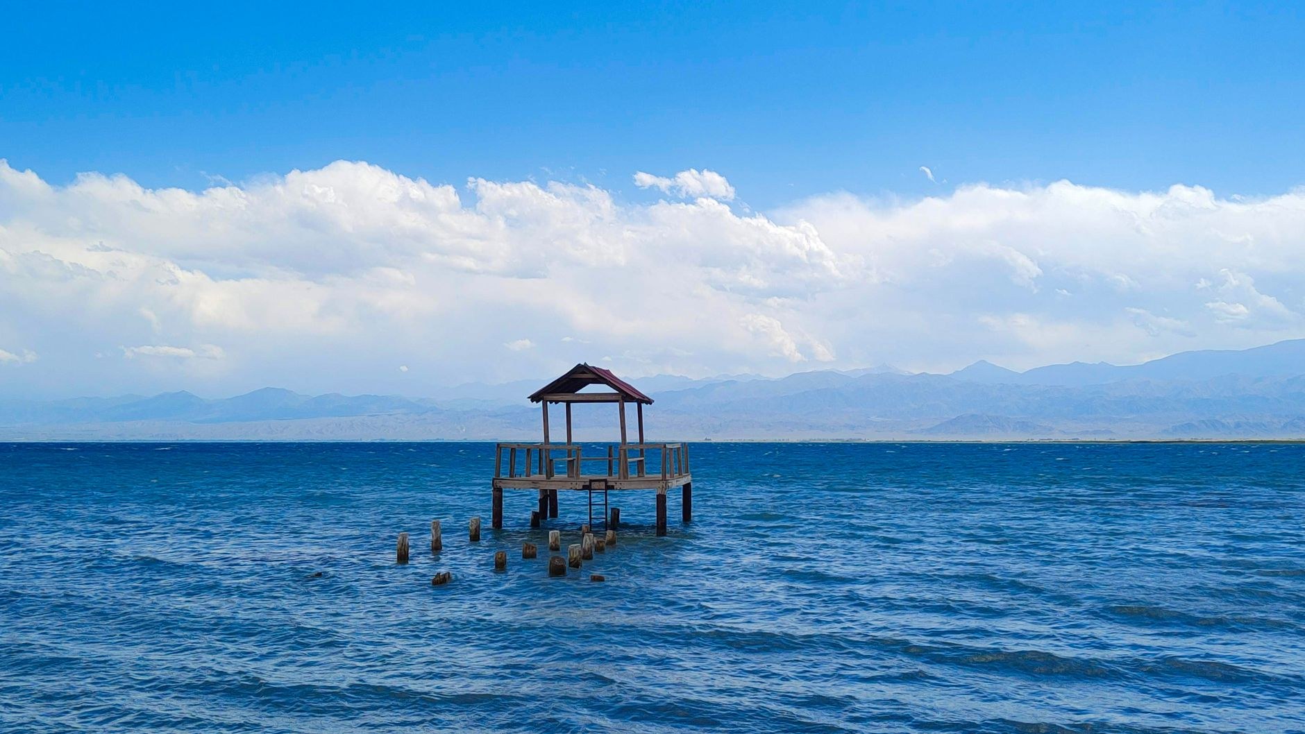 Vast turquoise waters of Lake Issyk-Kul framed by the snow-covered peaks of the Tian Shan mountain range