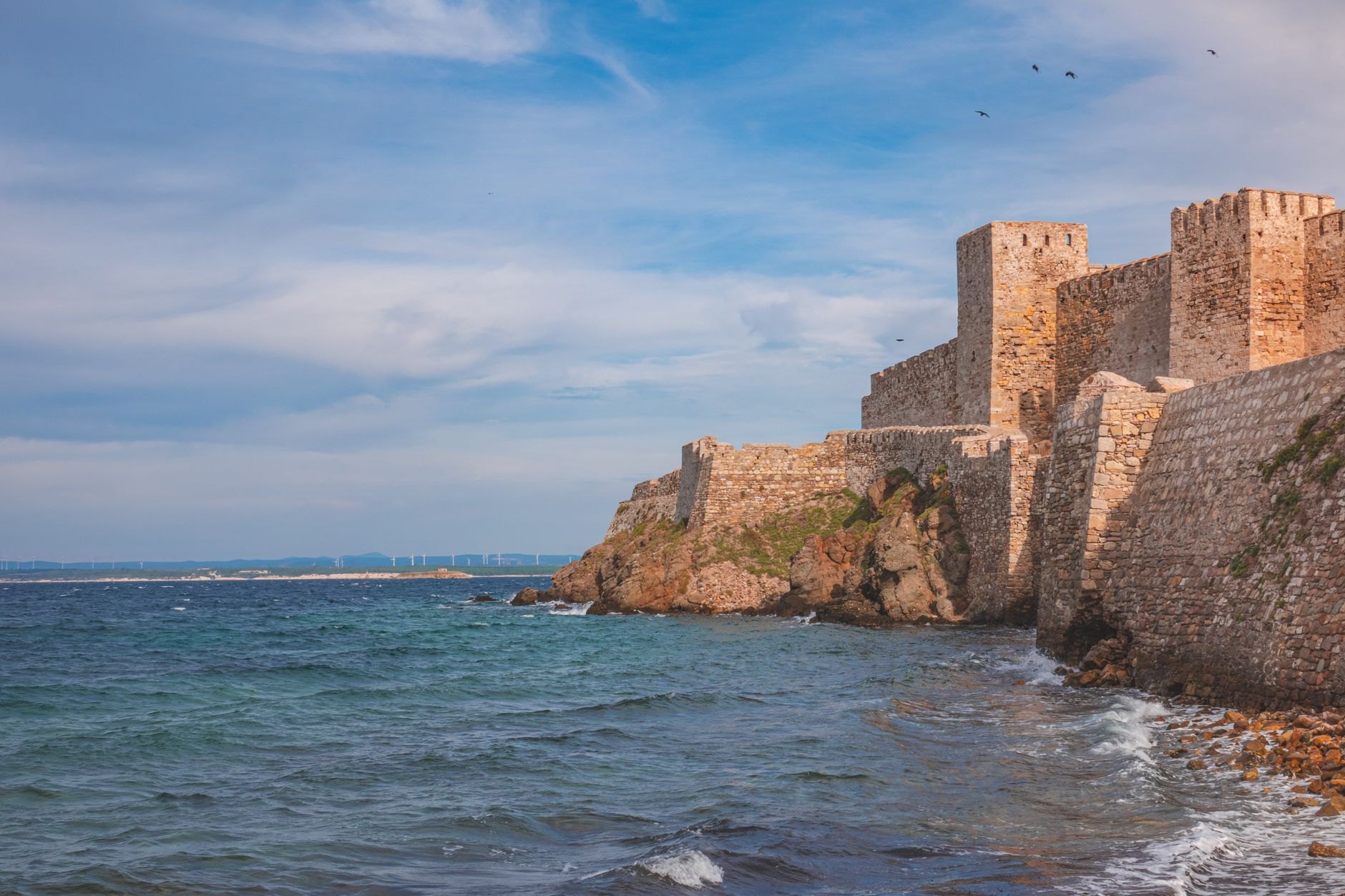 Historic fortified stone walls and arched cannon openings carved into the solid rock cliffs of the Bock