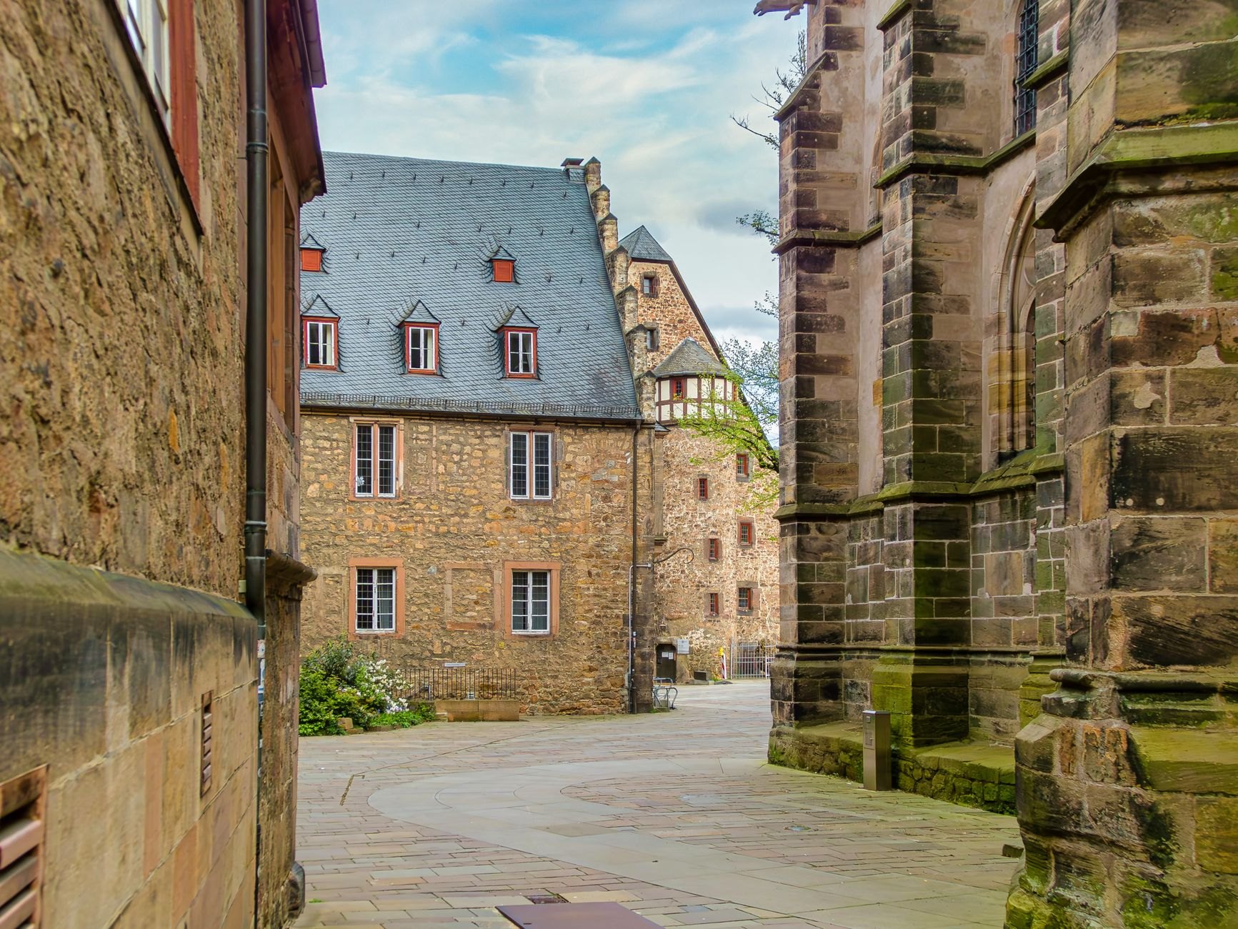 Cobblestone marketplace surrounded by historic merchant houses and the grand twin towers of Echternach Basilica