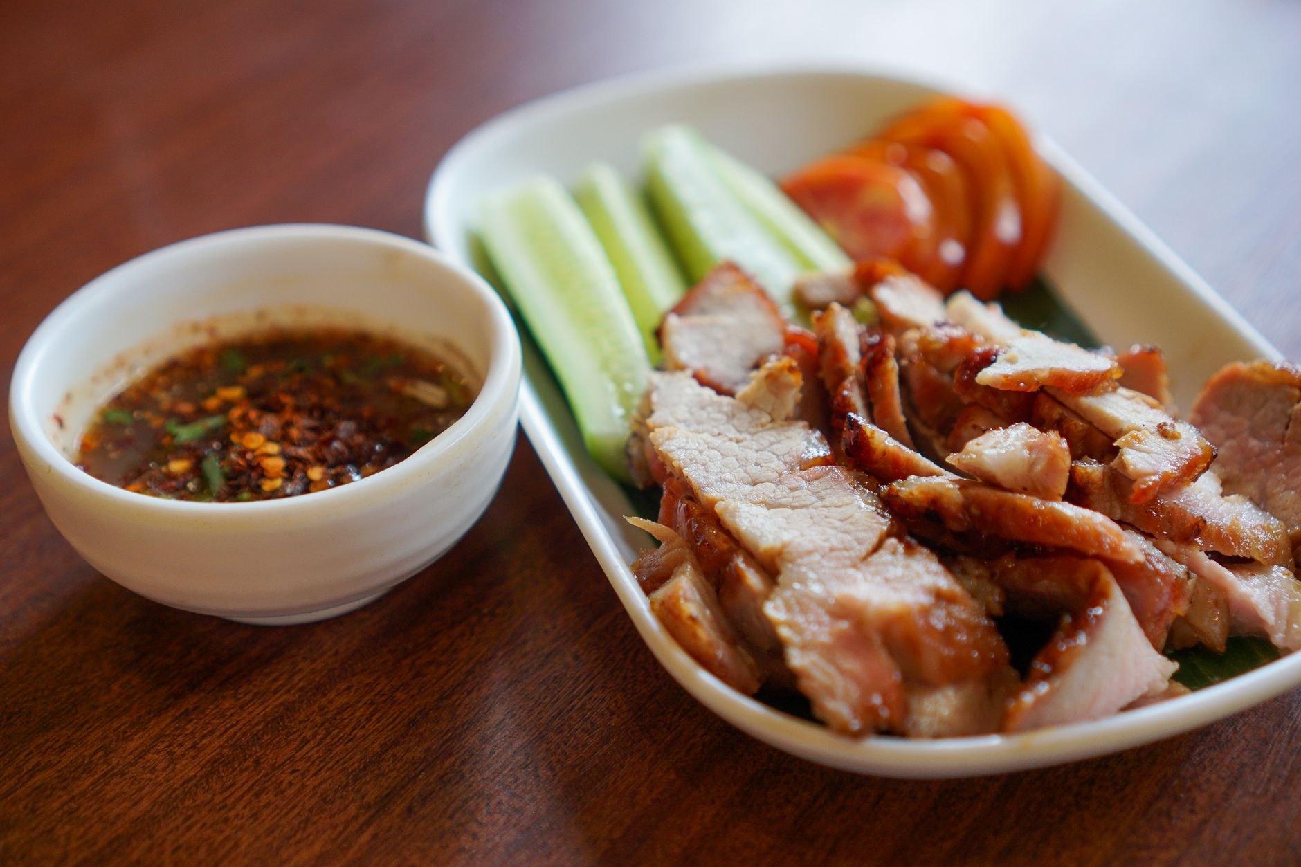 Hearty platter of smoked pork collar served with braised broad beans in a savory creamy bacon sauce and boiled potatoes