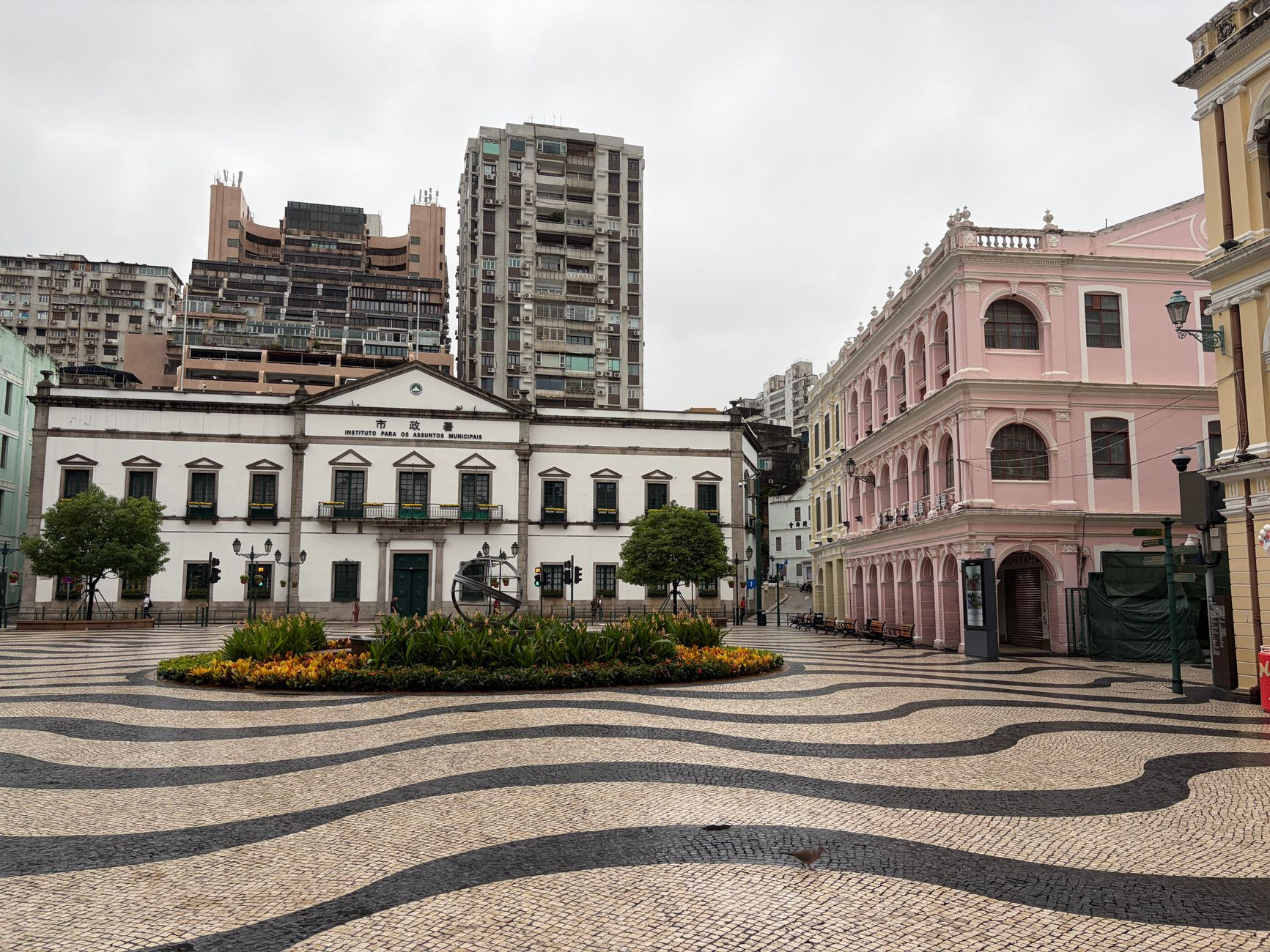 Senado Square in central Macao featuring pastel-yellow neoclassical colonial buildings and black and white wave-patterned Portuguese cobblestones