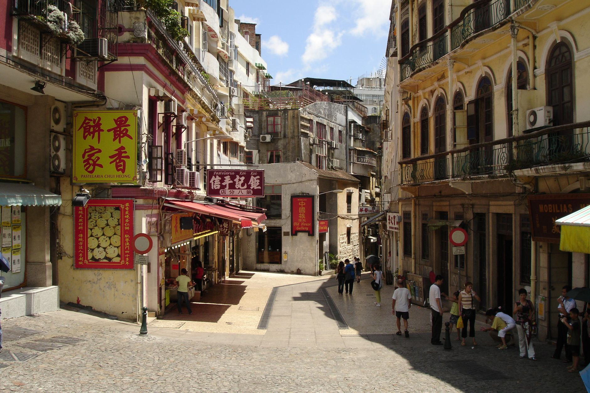 Charming pedestrian lane lined with traditional Macanese food shops, almond cookie bakeries, and historic street lanterns in Taipa Village
