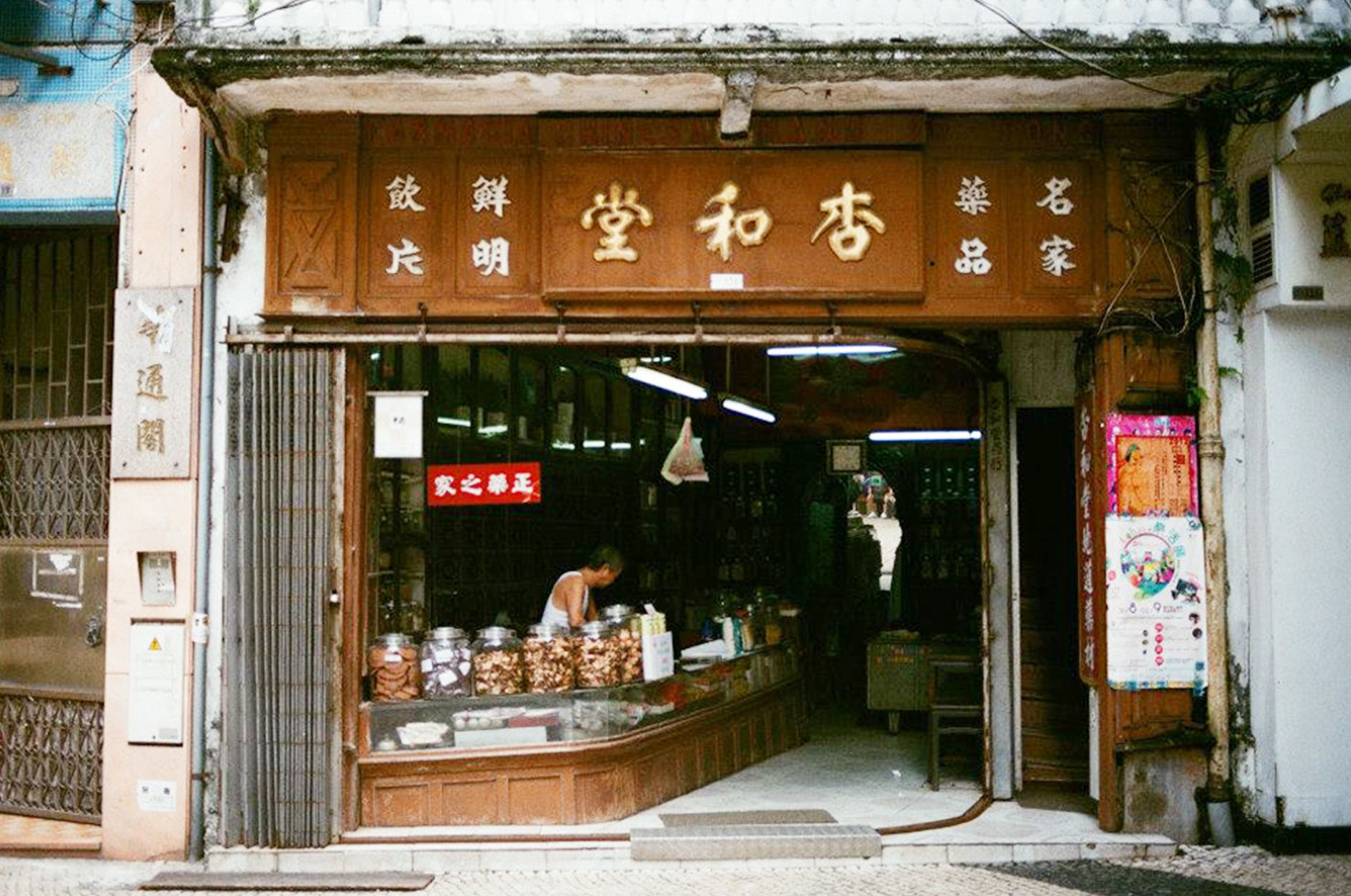Traditional wooden apothecary cabinets and ceramic herbal medicine jars inside a heritage Chinese trading shop in old Macao