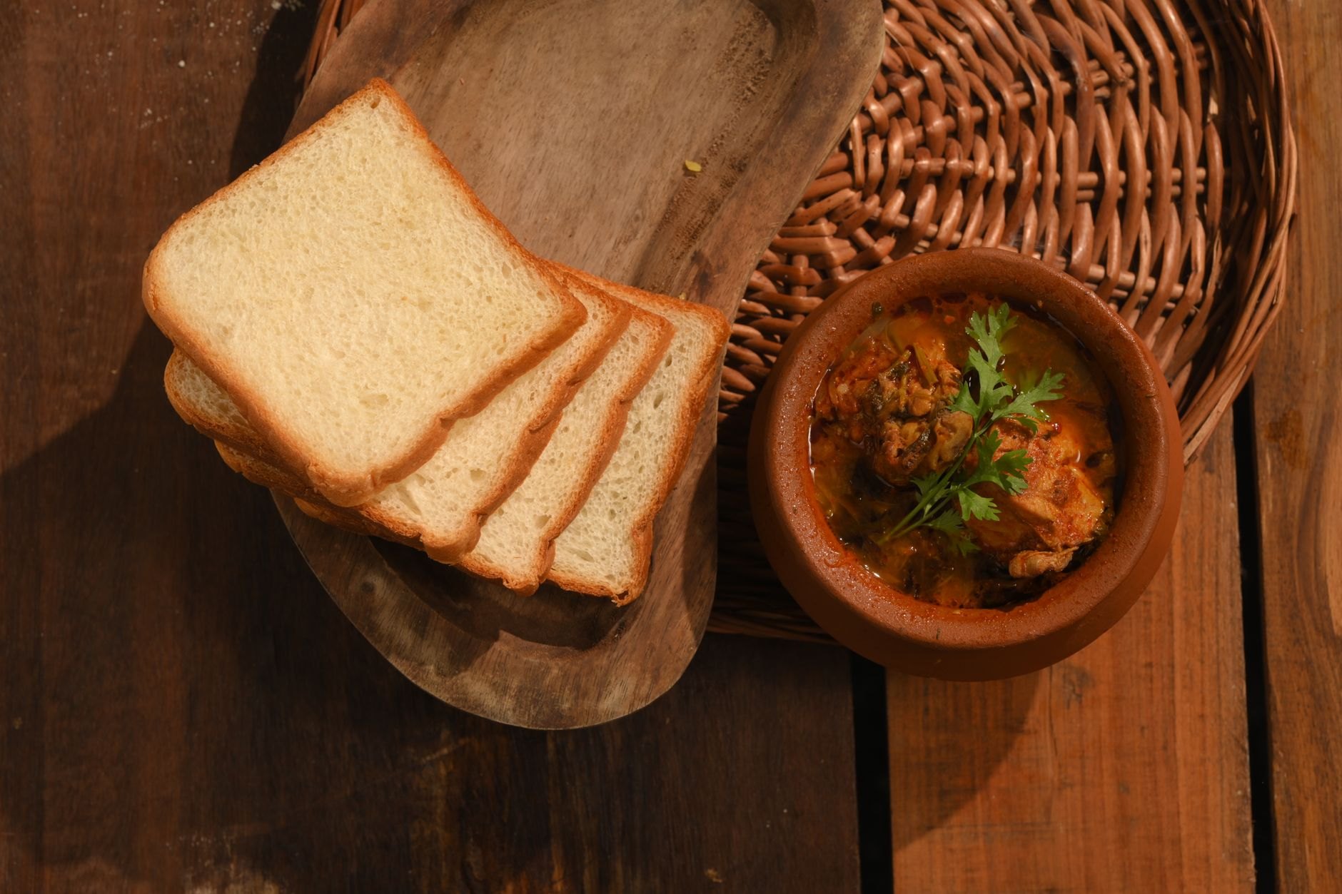 Savory baked white beans served in an authentic earthenware clay pot alongside crusty bread and grilled kebabs