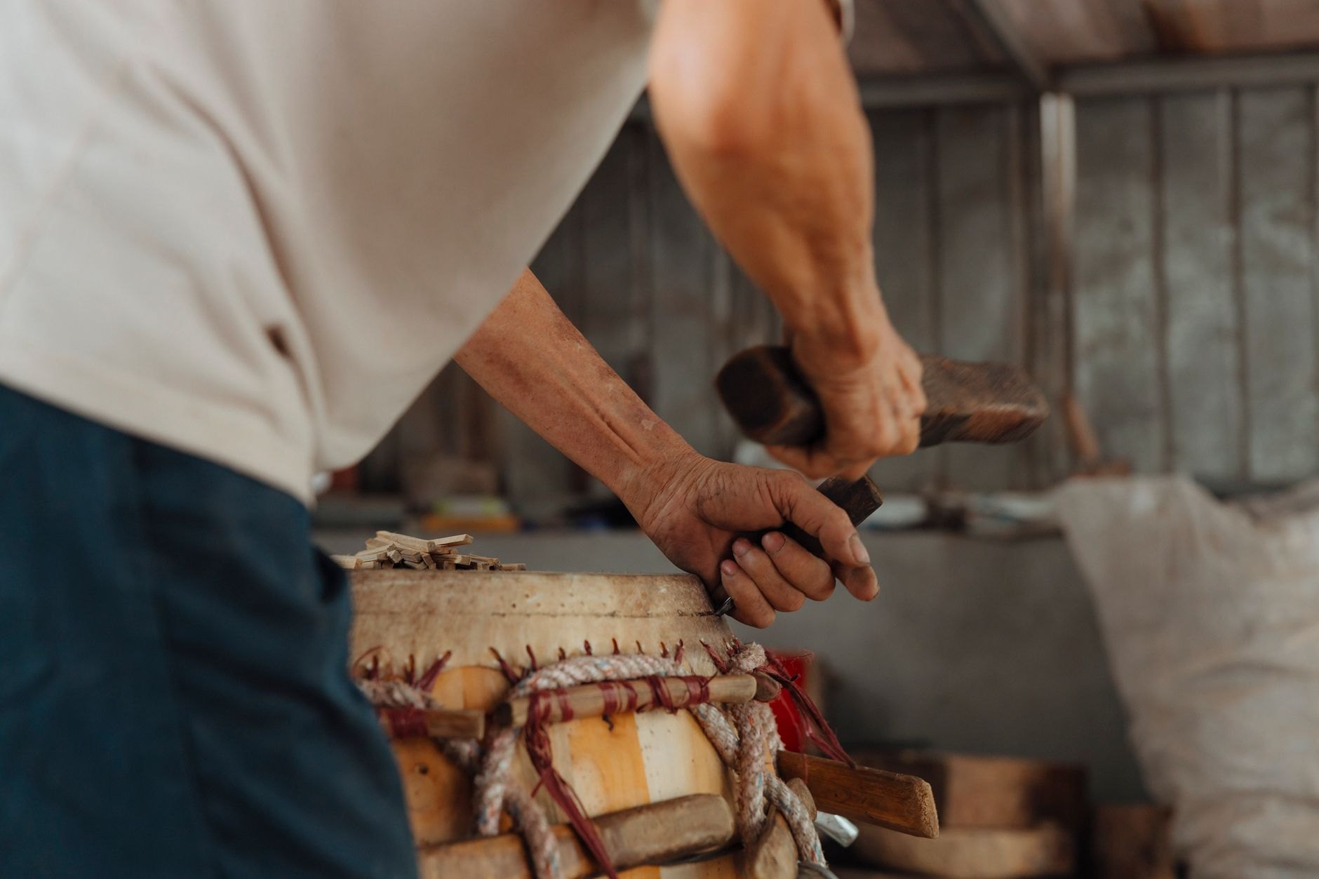 Skilled highland craftsman carving raw materials by hand inside a traditional artisan workshop in Antsirabe