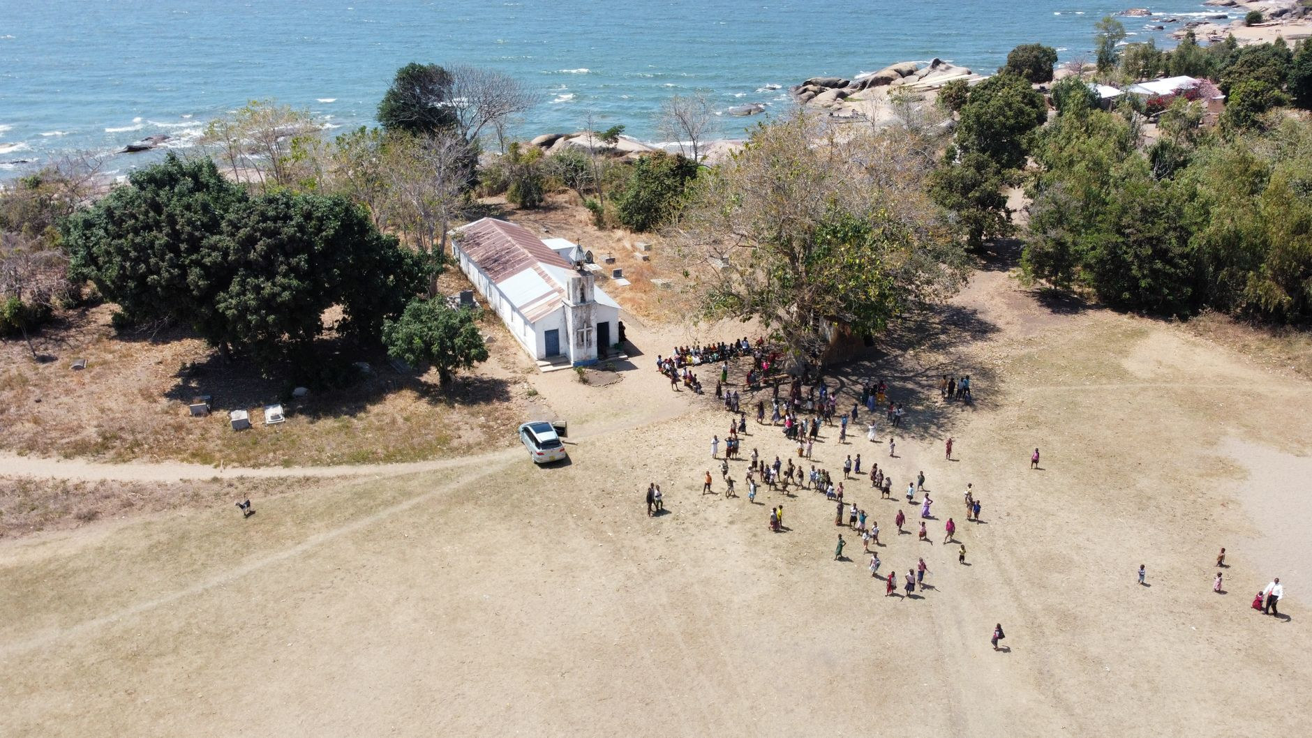 Aerial perspective over a peaceful rural community settlement bordering the deep blue waters of Lake Malawi