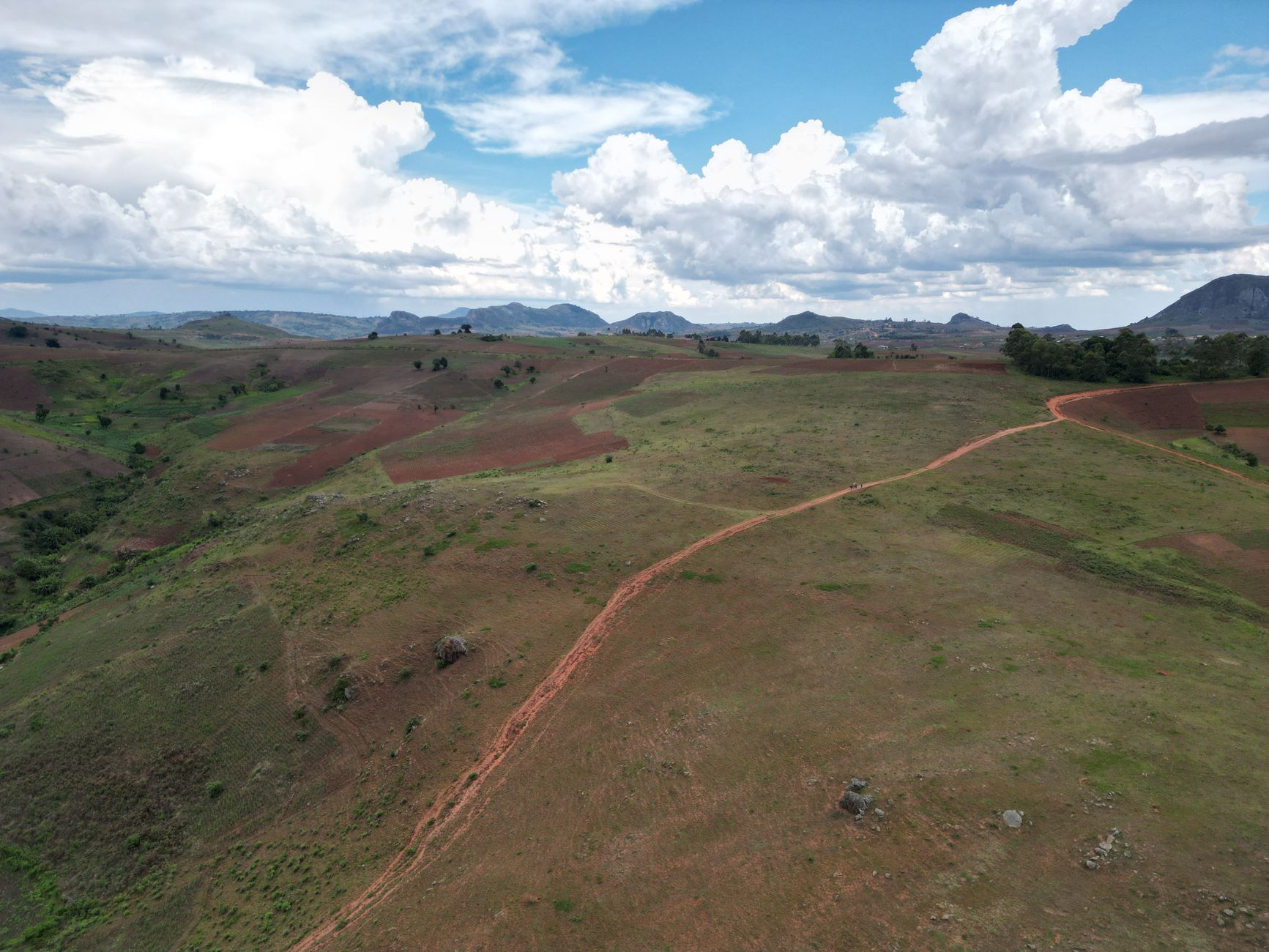 Aerial panoramic perspective over the rolling green ridges, river valleys, and forested hills of the Malawian highlands