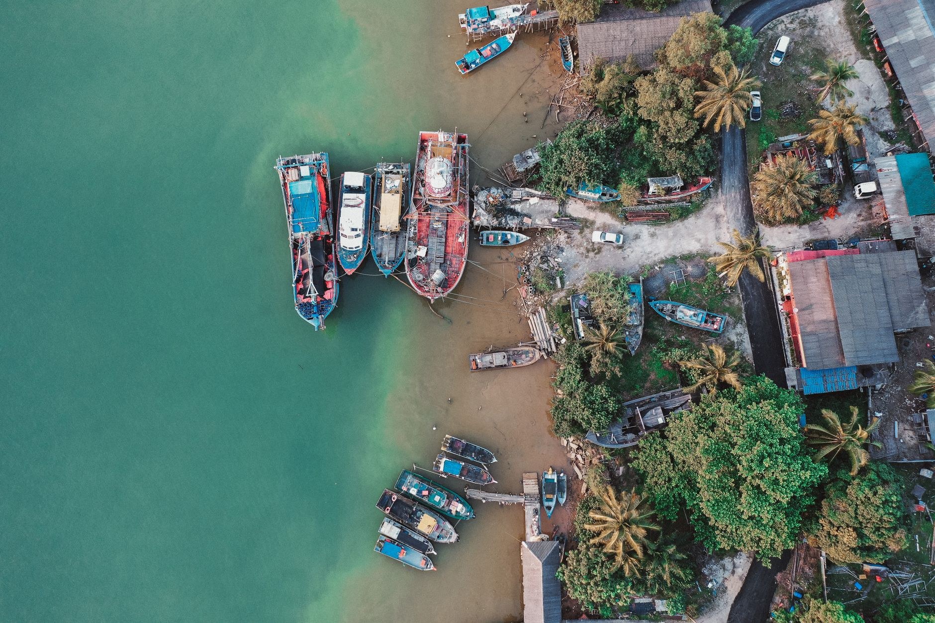Traditional wooden Maldivian dhoni fishing boats moored in turquoise harbor waters beside the capital waterfront