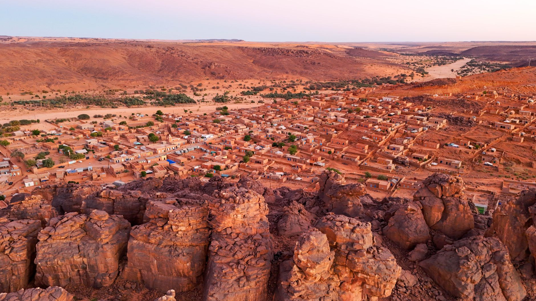 Drone view over a remote stone village surrounded by rocky canyon ridges in Mauritania Adrar plateau