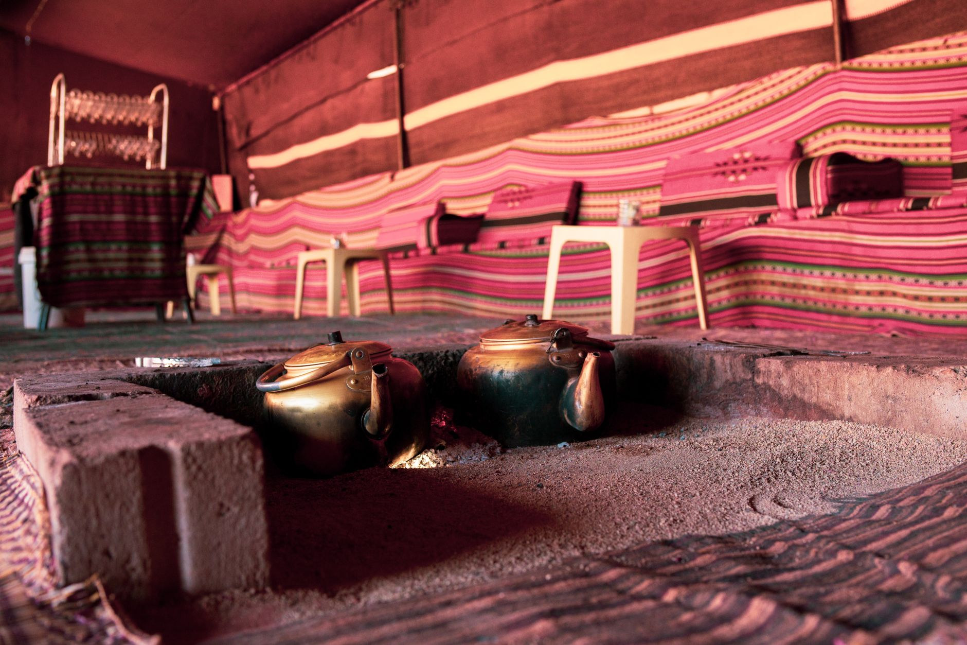 Traditional brass teapots and glasses prepared for the Saharan mint tea ceremony inside a desert nomad tent