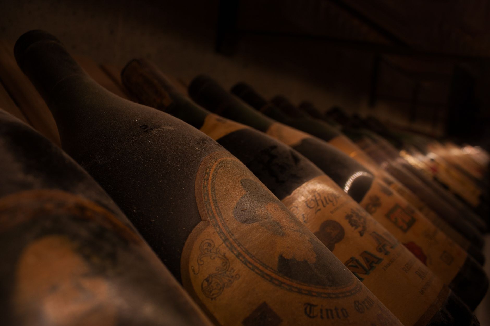 Limestone niches filled with hundreds of vintage dusty wine bottles recumbent in cool cellars